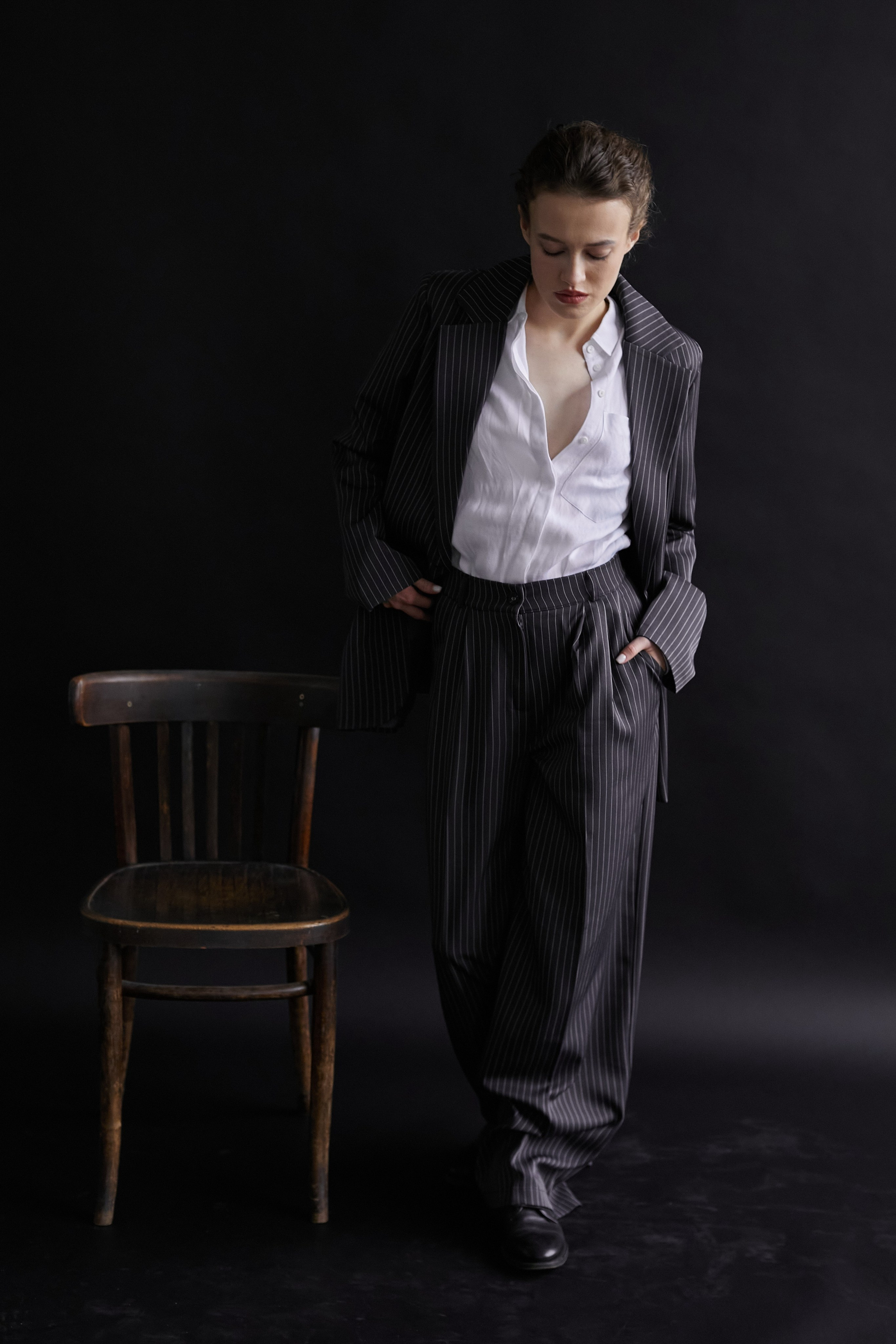 Фотограф в Москве. Студия. Студийный портрет. Девушка в пиджаке. Девушка на стуле на черном фоне. Красивая девушка в мужском костюме. Женский портрет.