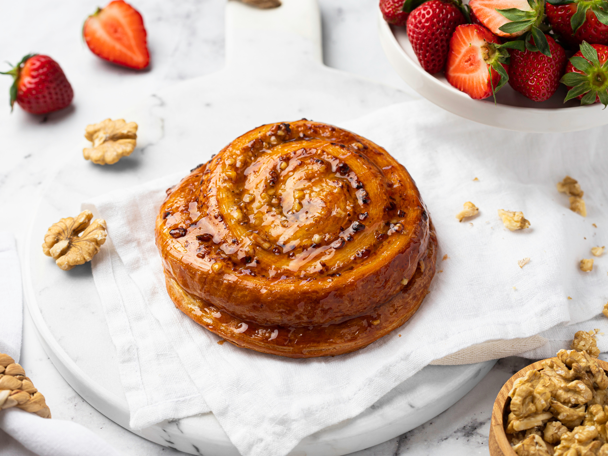 Евгения Морозова. Предметный коммерческий фуд фотограф. Москва. Булочка с орехами и клубникой на белом фоне высокий ключ фудстайлинг