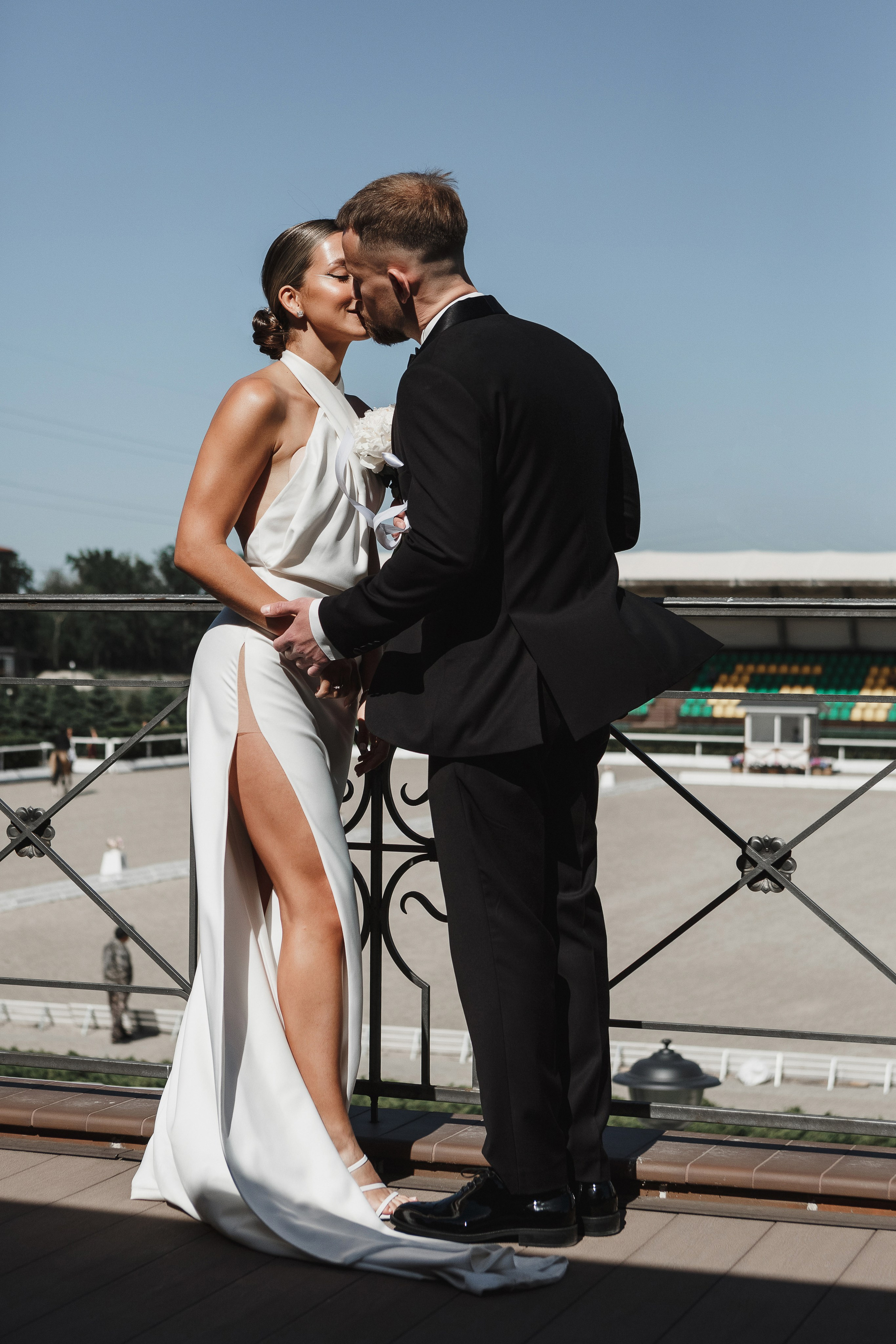 Жених целует невесту на террасе Golden Horse в Таганроге во время свадебной фотосессии, фотограф Антон Бакарюк