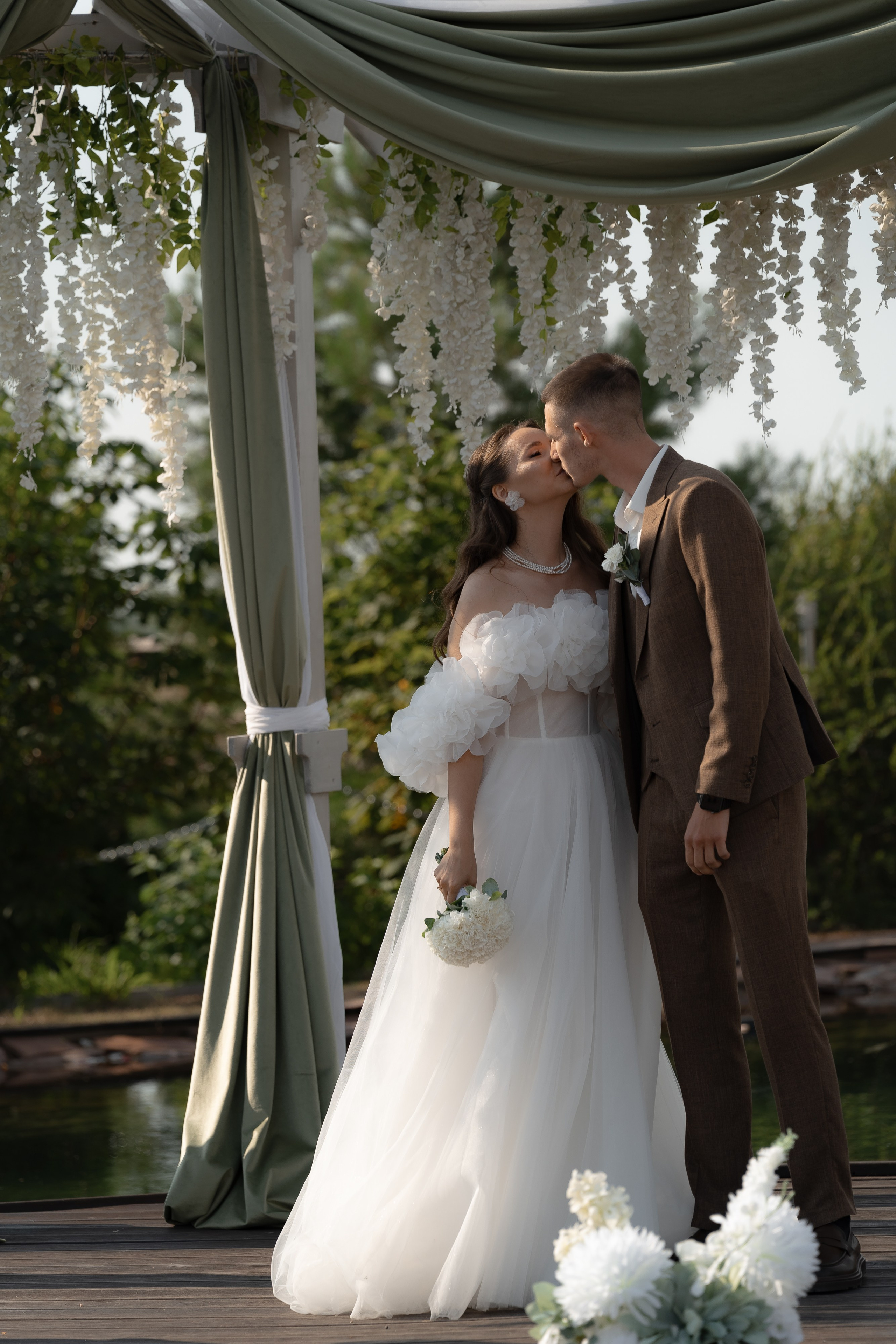 Первый поцелуй молодожёнов под свадебной аркой, момент завершения церемонии