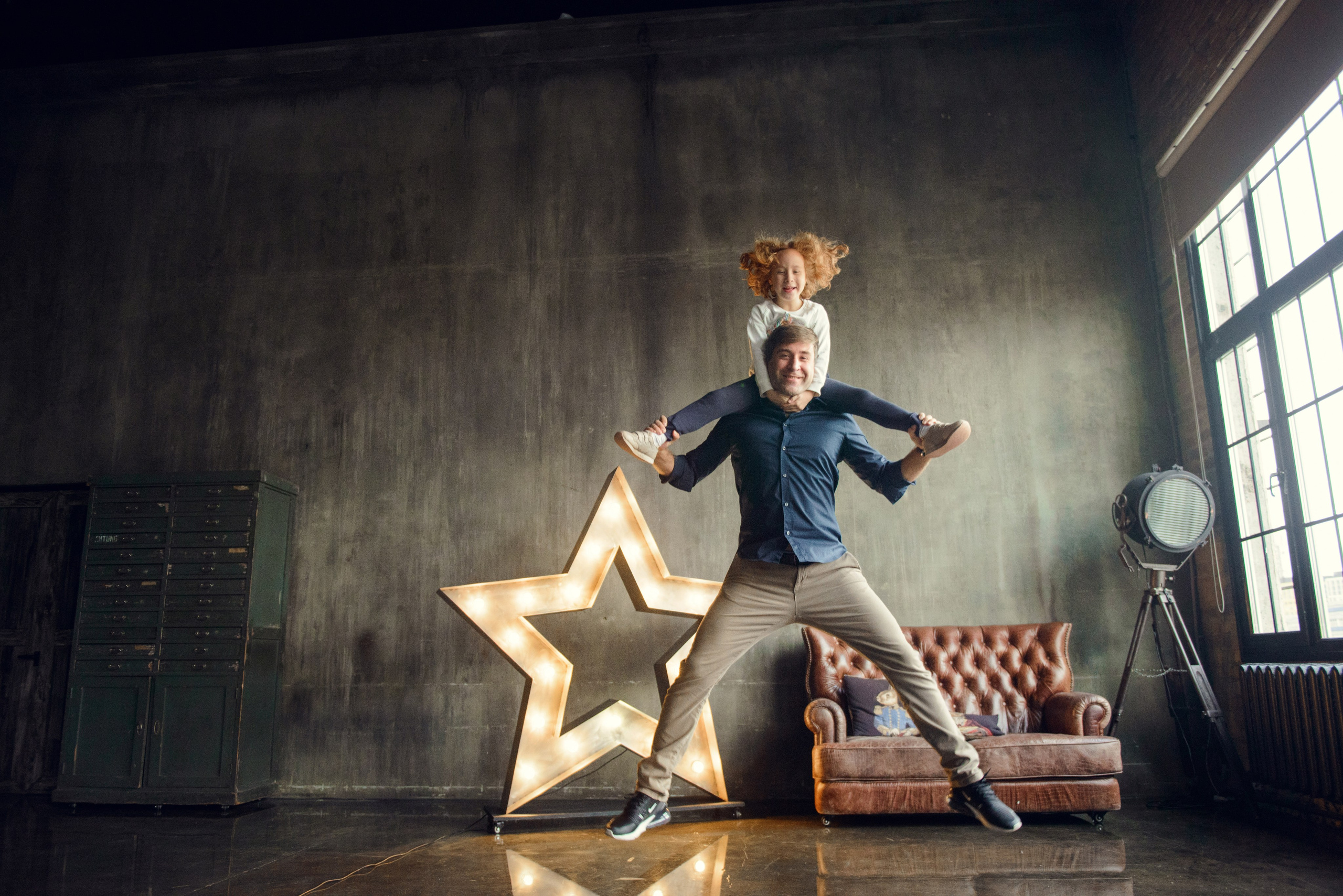 dad and daughter in a dark photo studio