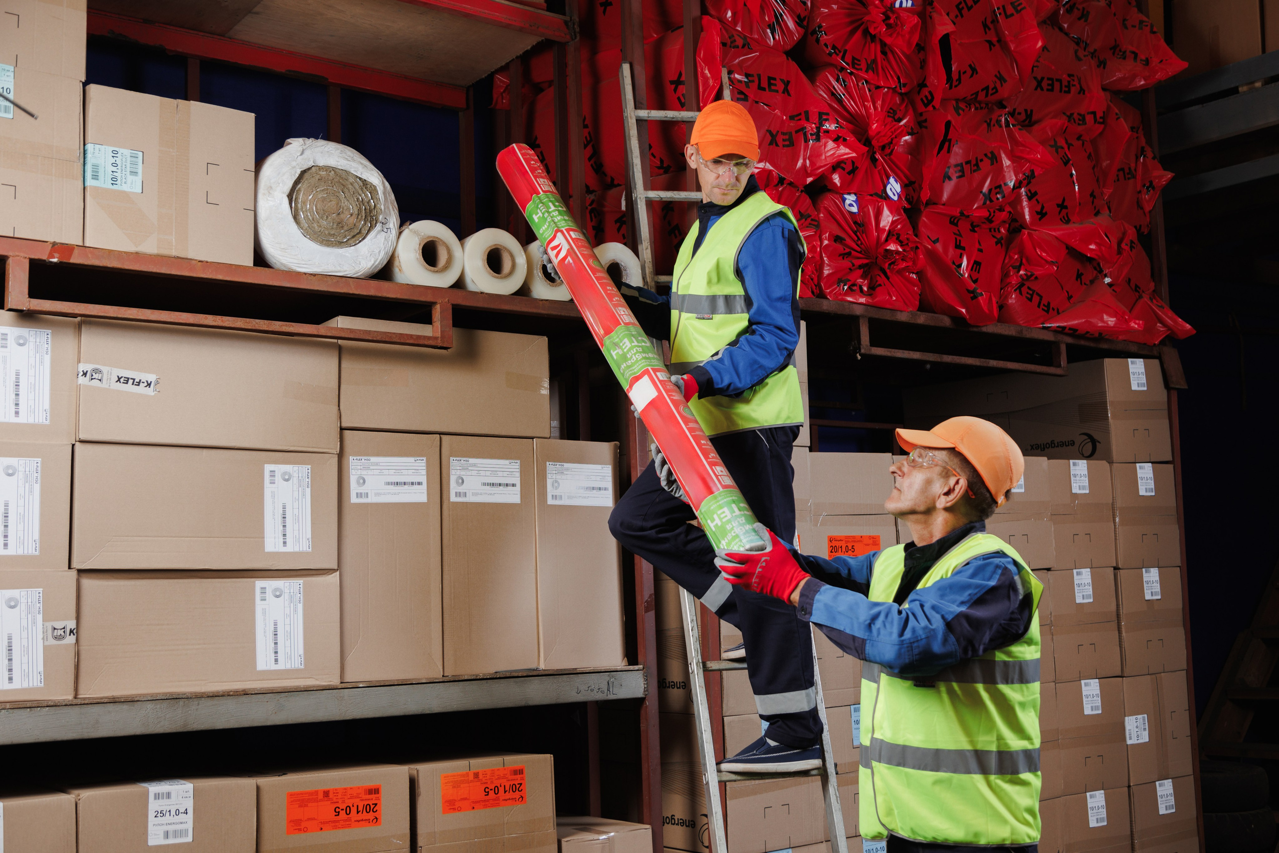 Два складских работника проверяют и упаковывают товар. Работа в логистическом центре.