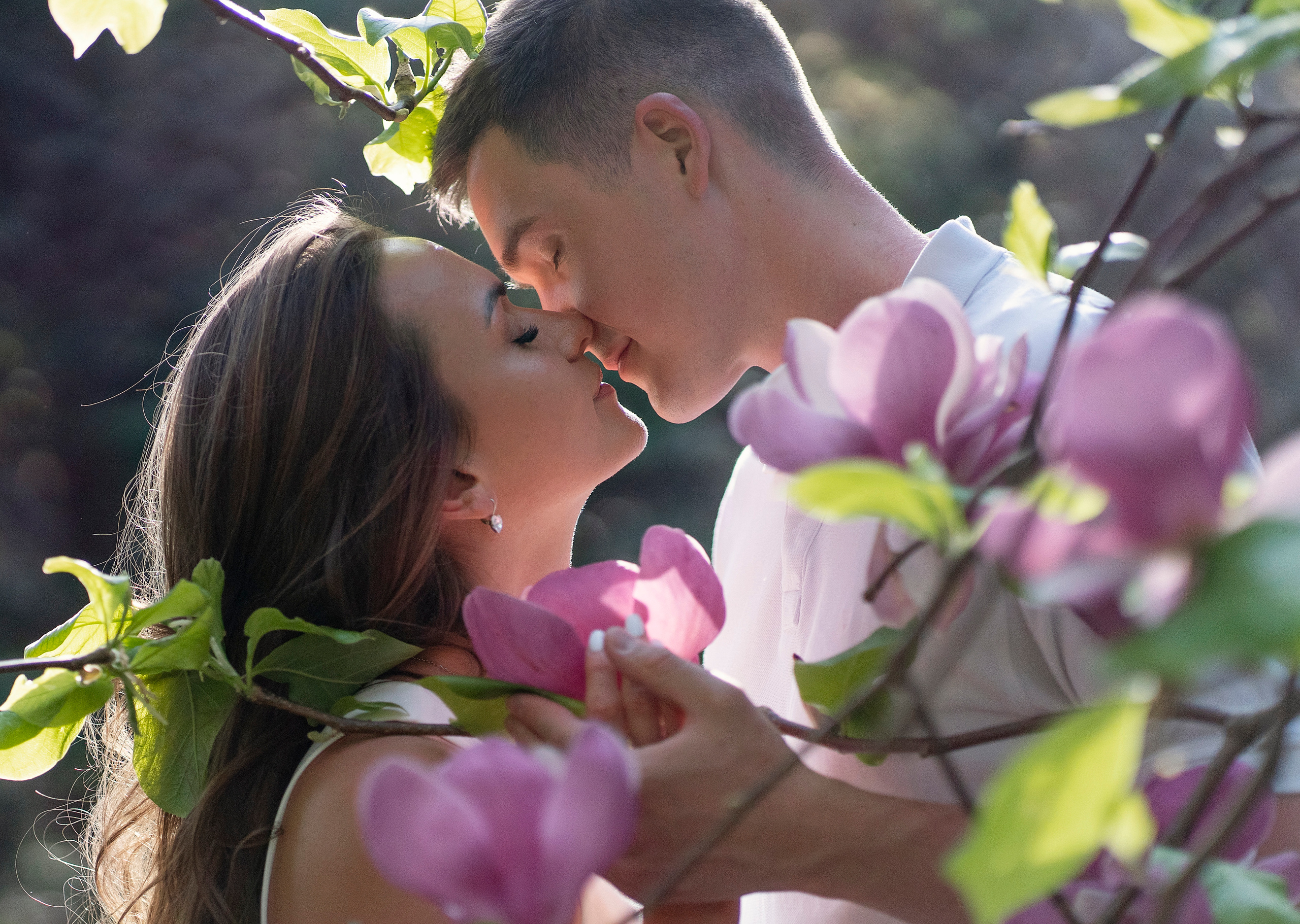 Парень и девушка целуются в магнолии. Парк Южные культуры. Адлер.