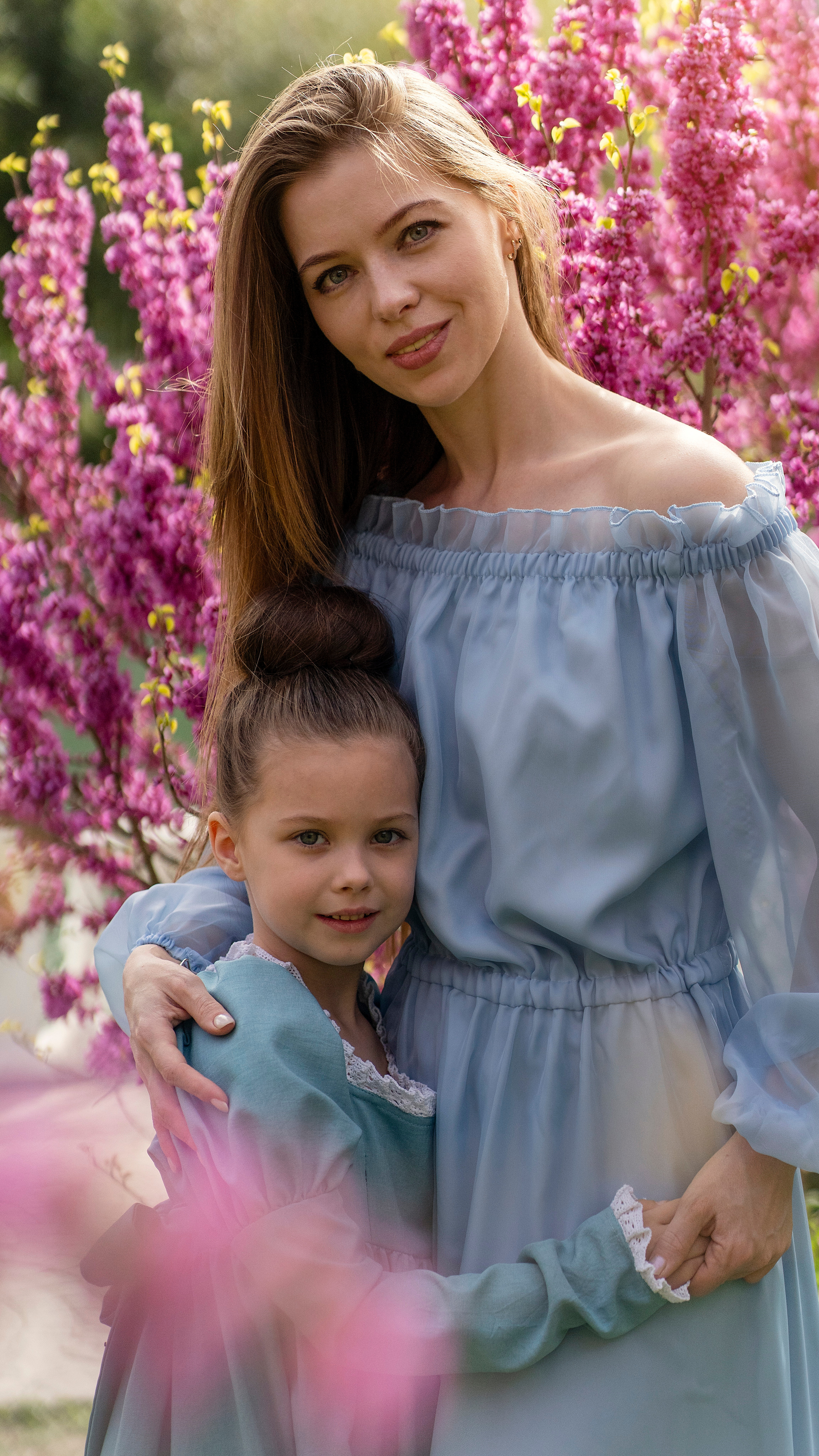 Мама с доченькой любуются цветущей сакурой.