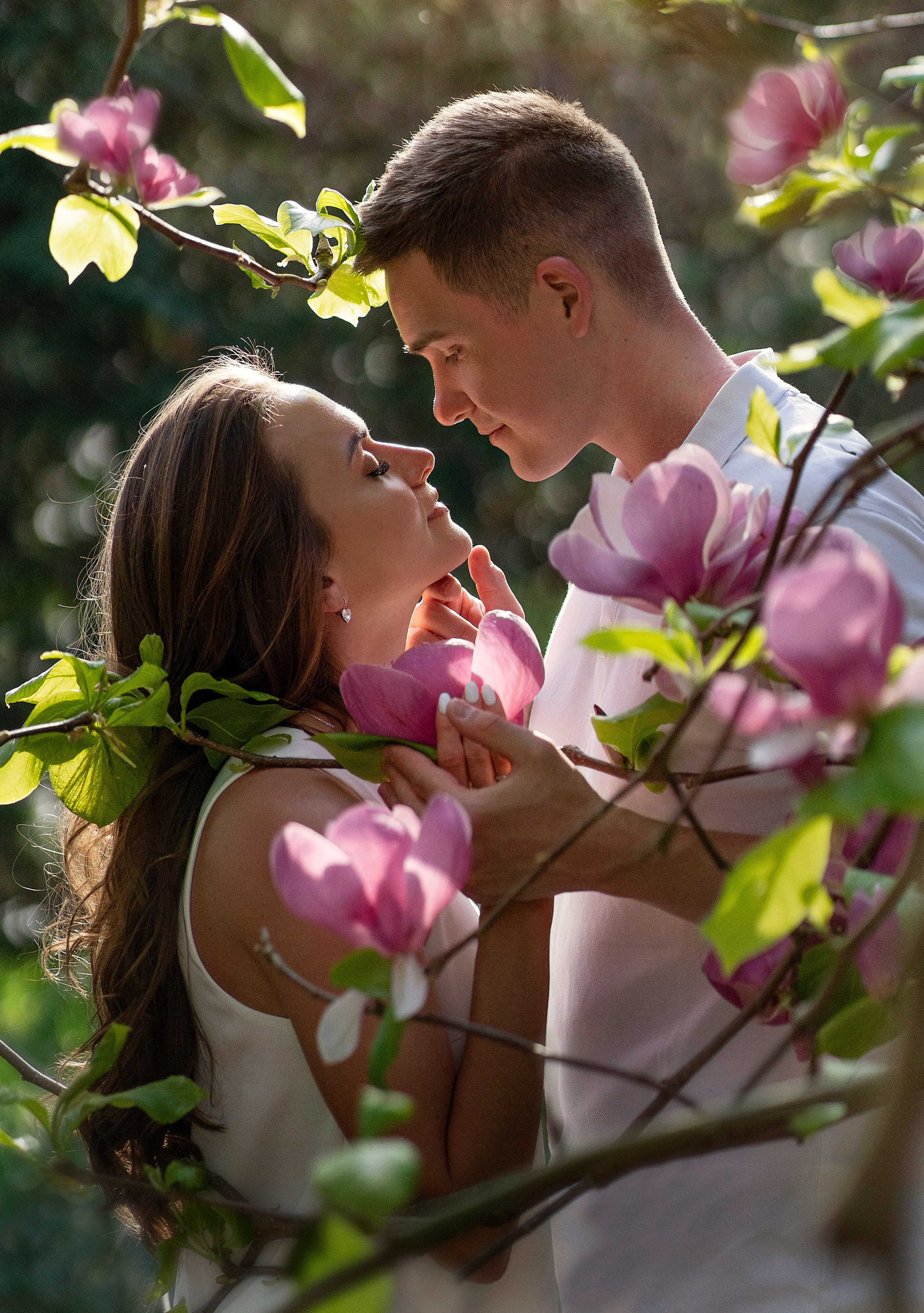 Двое, на фоне цветущей магнолии, смотрят друг на друга.