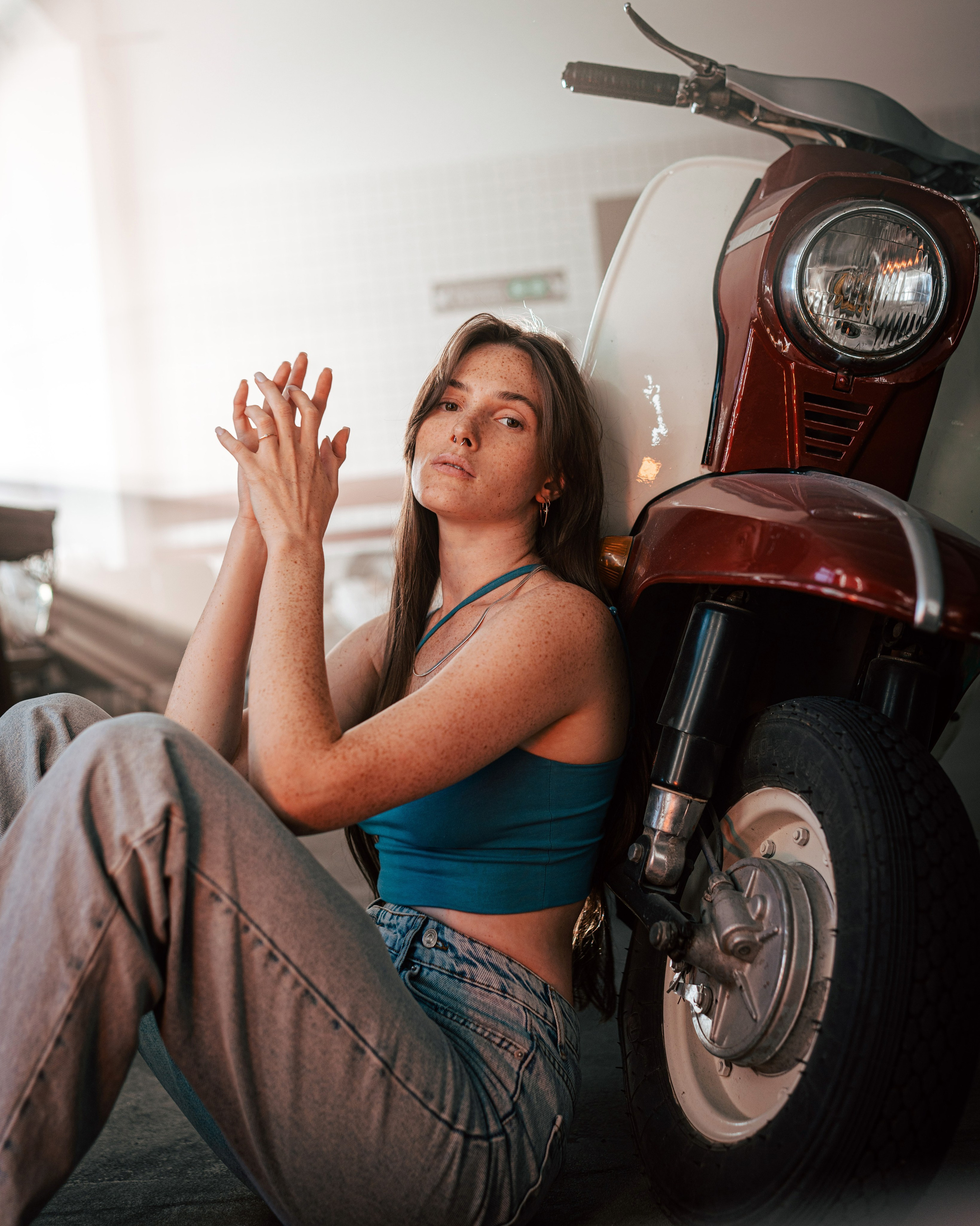 Студийная фотография девушки у мотоцикла
