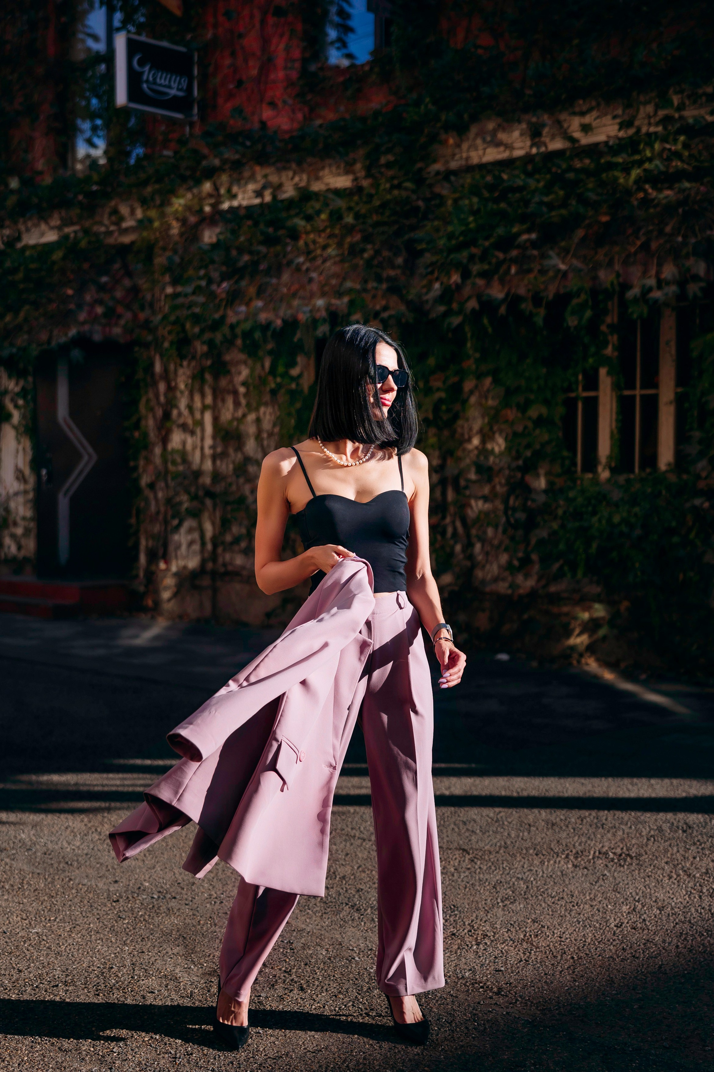 ростовой портрет девушки в розовом костюме в солнечных лучах