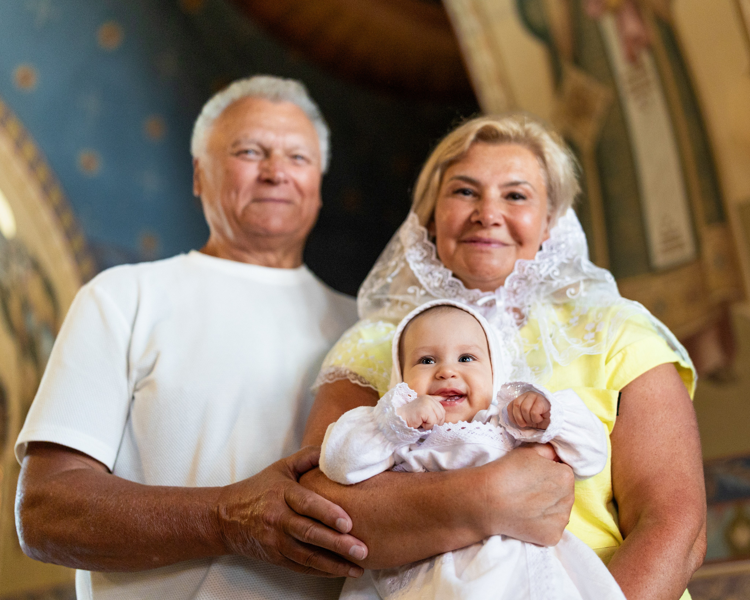 Фотография девочки с бабушкой и дедушкой после крещения 