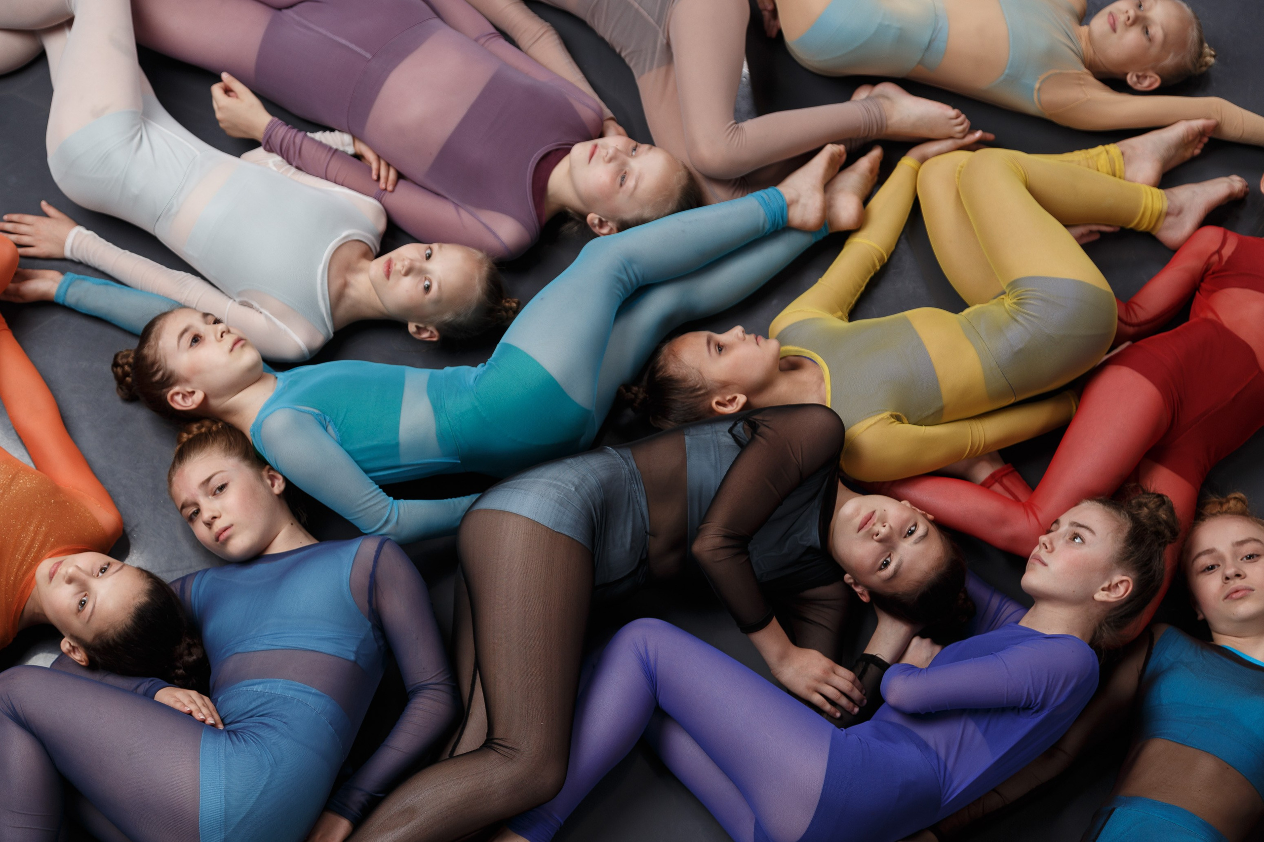 Группа молодых балерин в растяжке, яркие костюмы для профессиональной балетной фотографии талантов