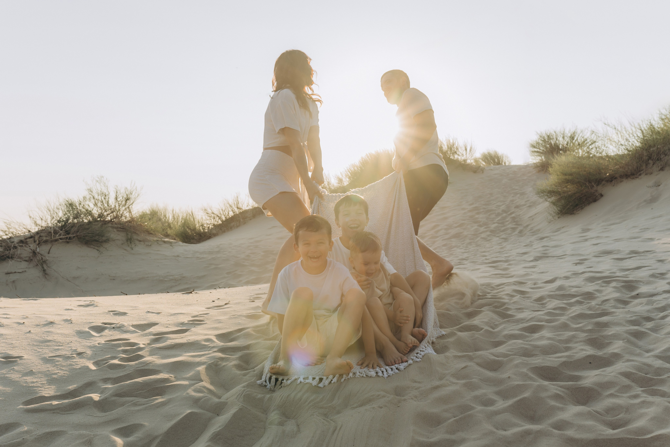 Семья в движении: прыжки, объятия и веселье на пляже