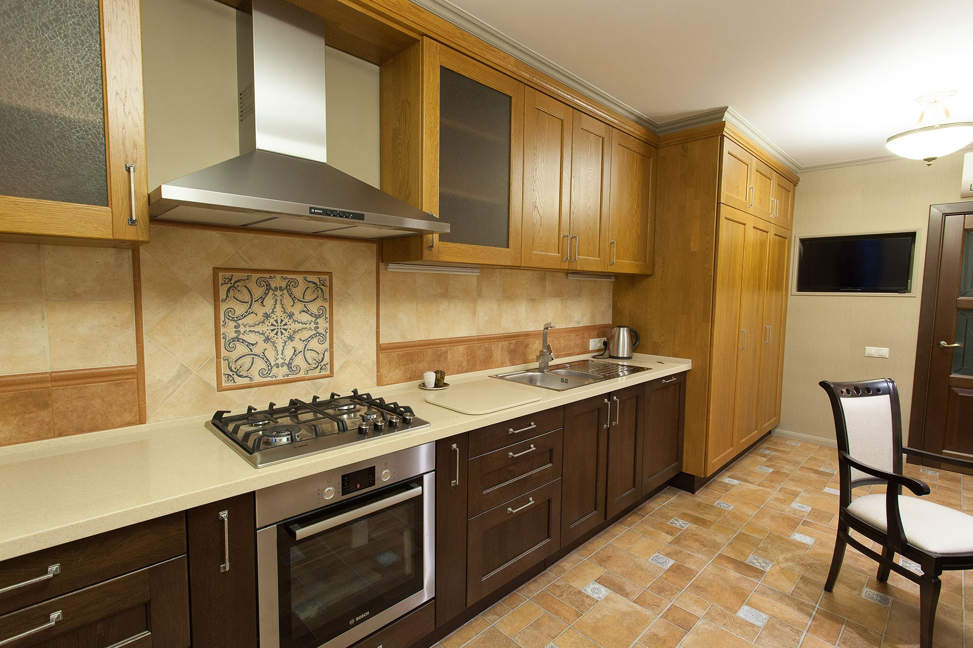 Интерьерная фотография кухни квартиры, вид на рабочую поверхность и встроенную технику.