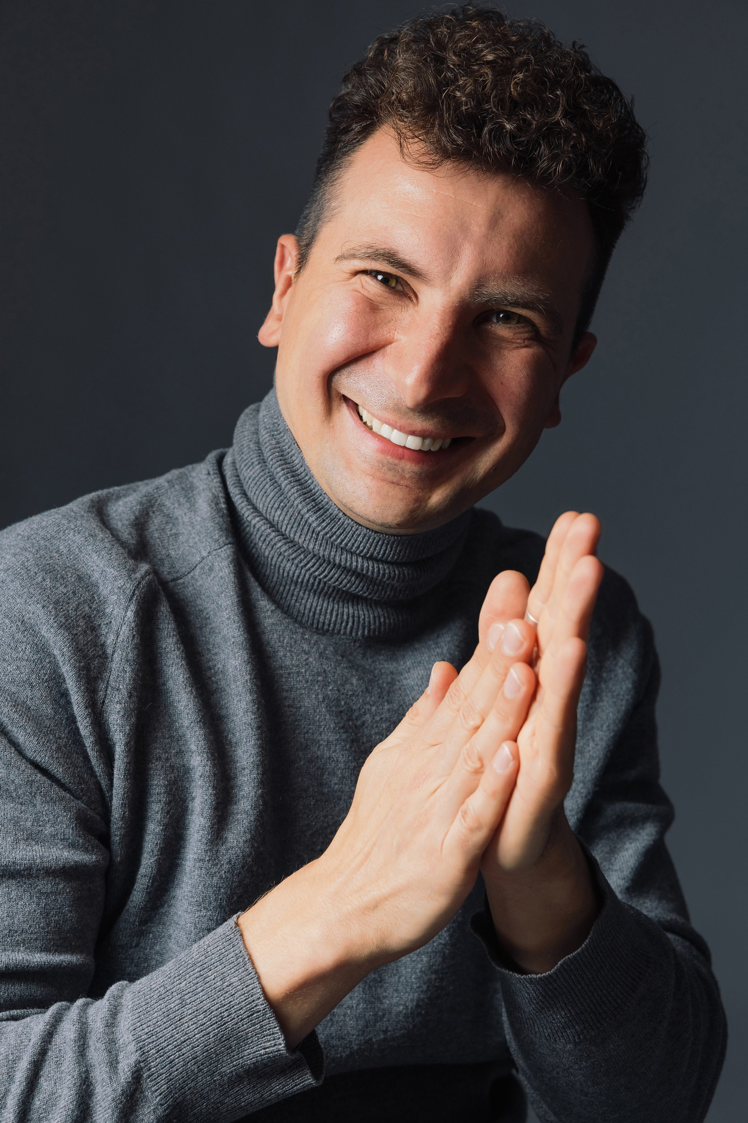 Портрет мужчины в серой водолазке в студии