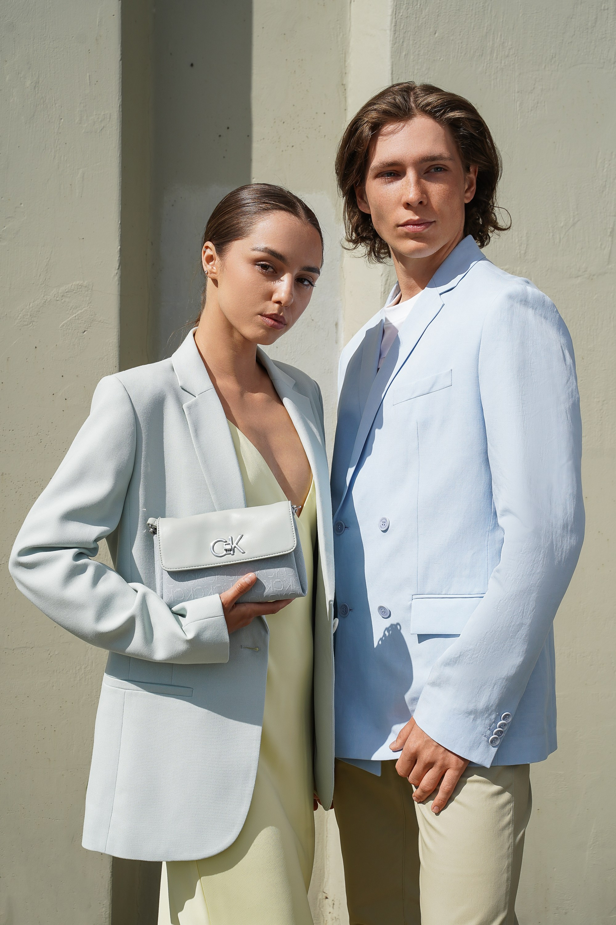 Девушка и парень фотомодели позируют в голубых пиджаках