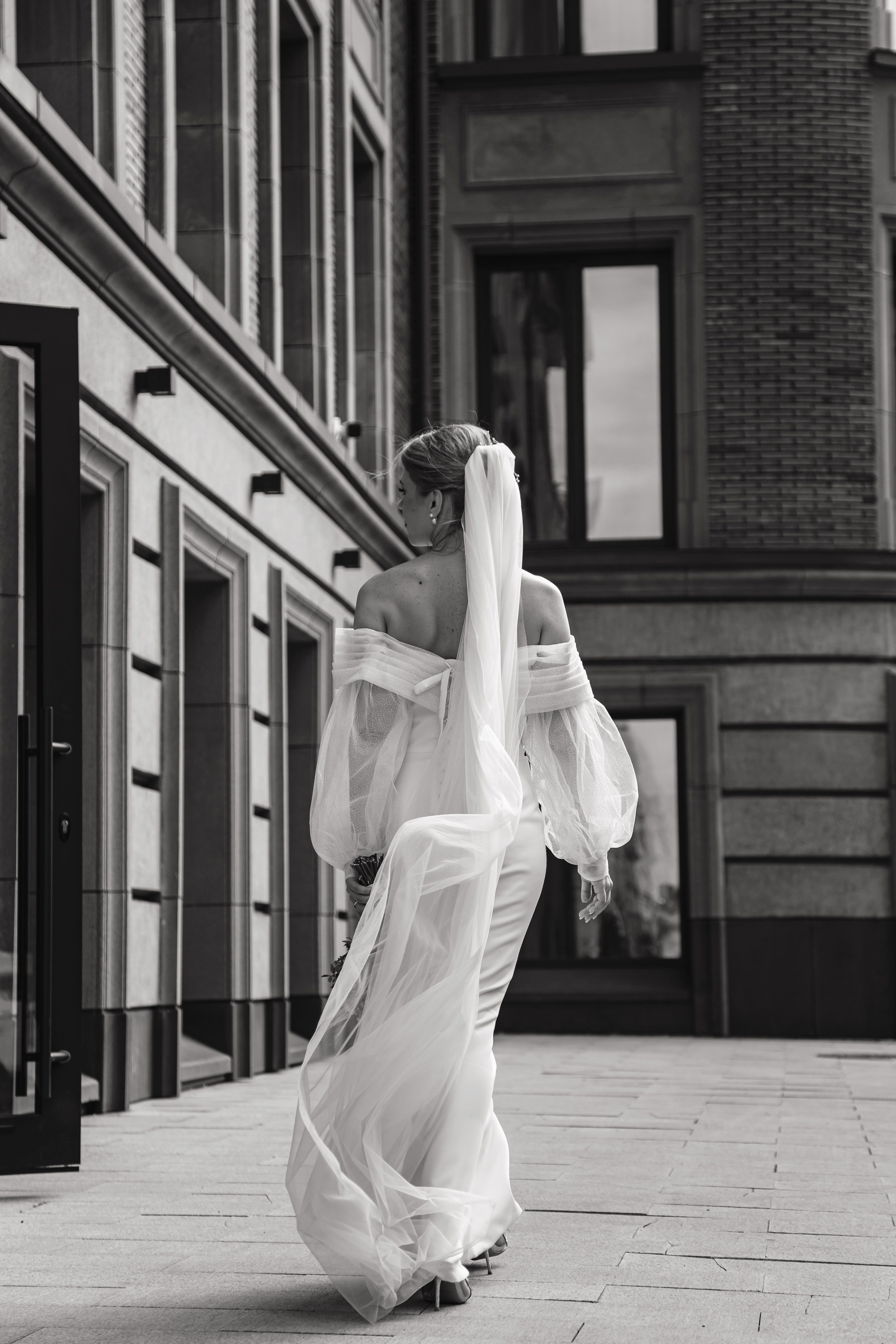 Невеста в свадебном платье идёт по улице в Москве.