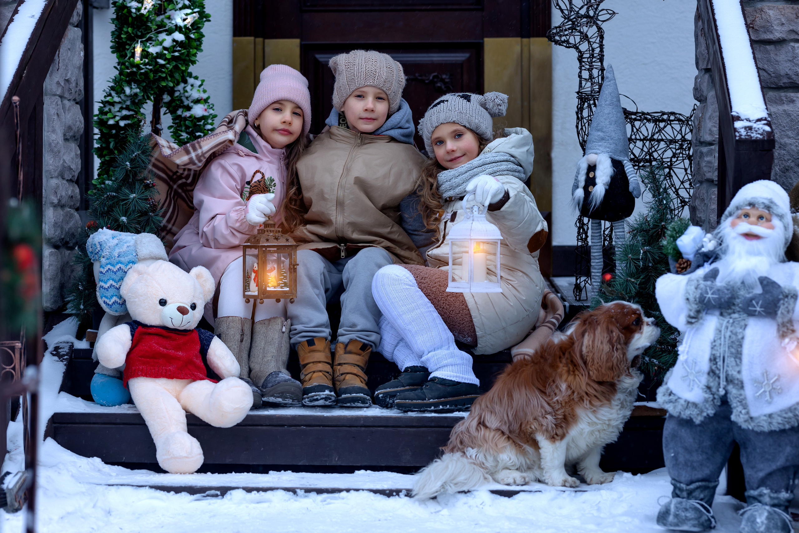 Счастливые дети на новогоднем крыльце возле дома