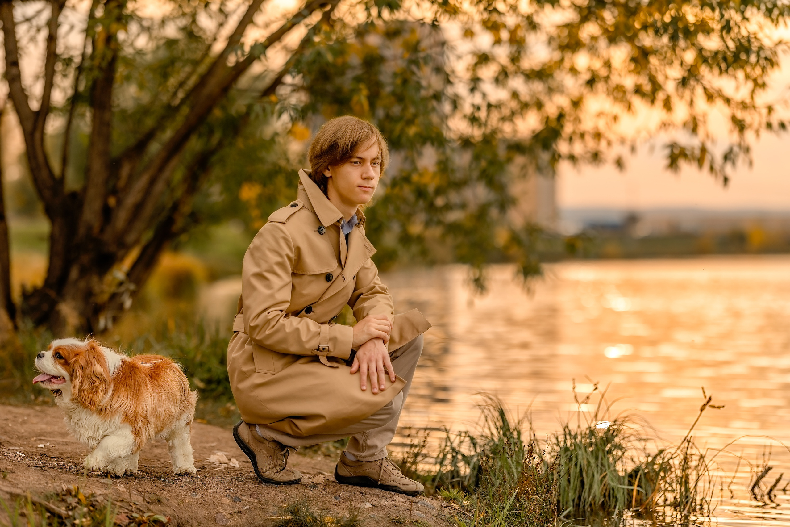 Мужчина с собакой возле озера осенью
