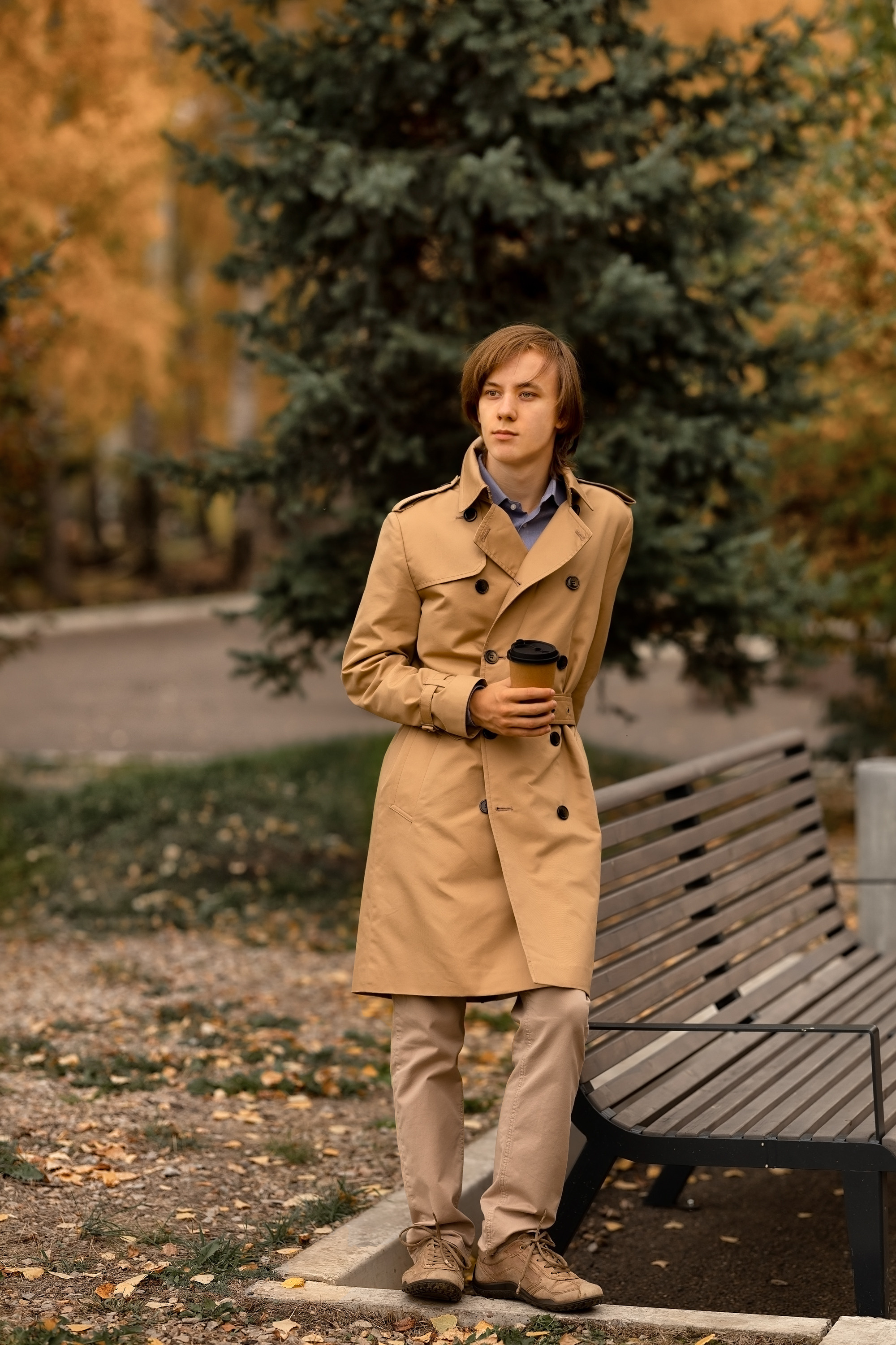 Счастливый мужчина осенью в парке пьет кофе