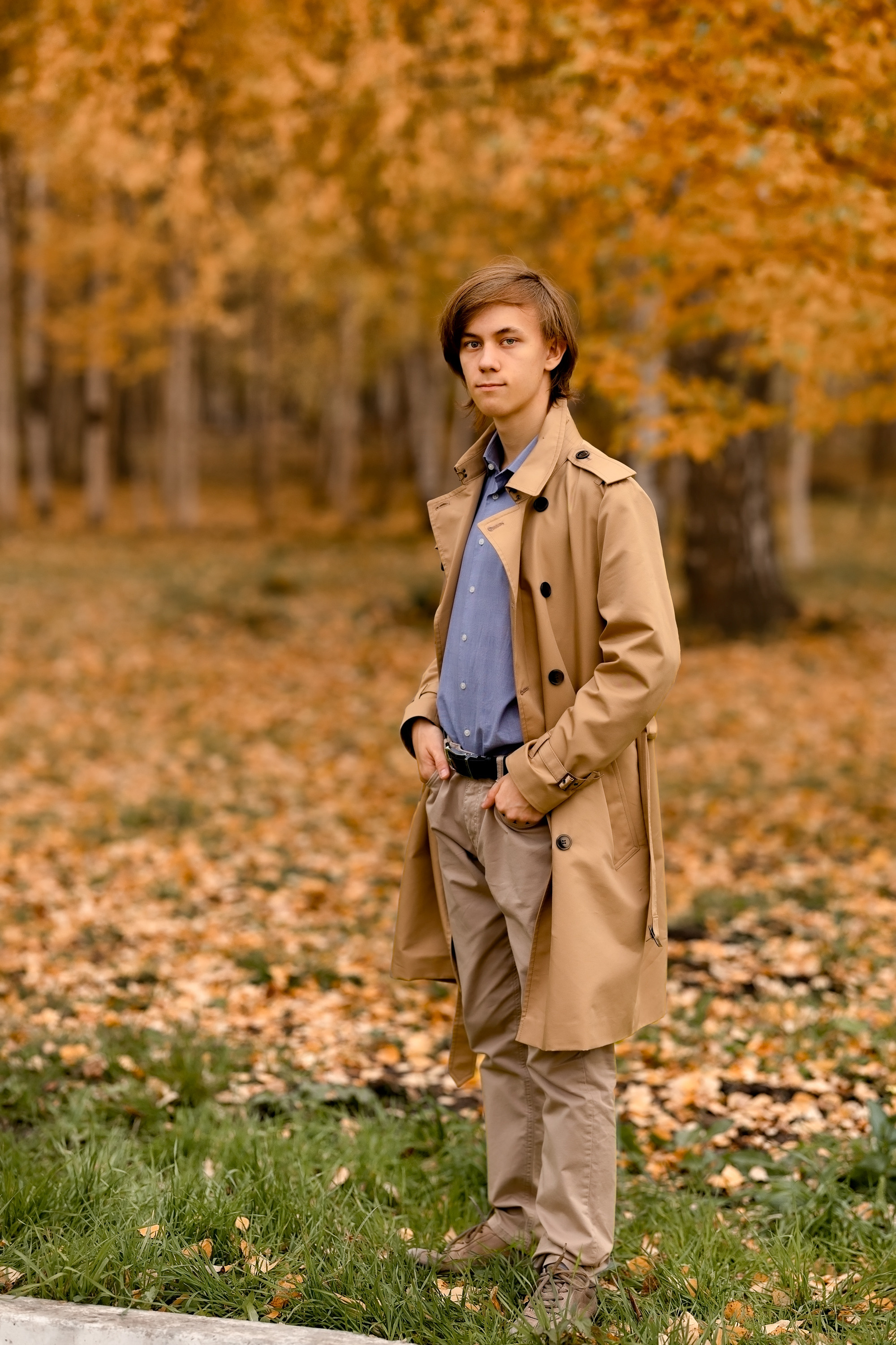 Счастливый мужчина осенью в парке возле берез