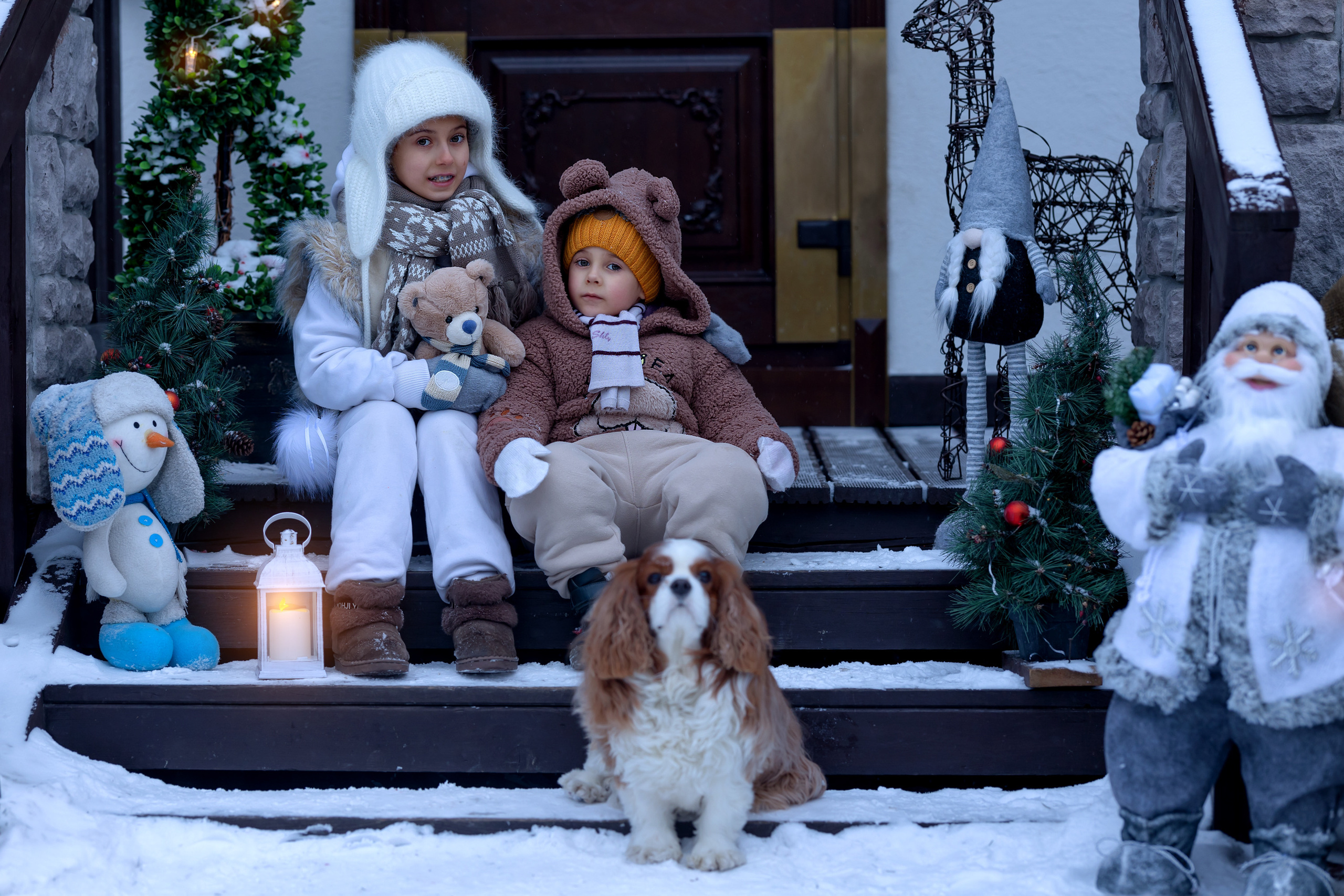 Счастливые дети на новогоднем крыльце возле дома