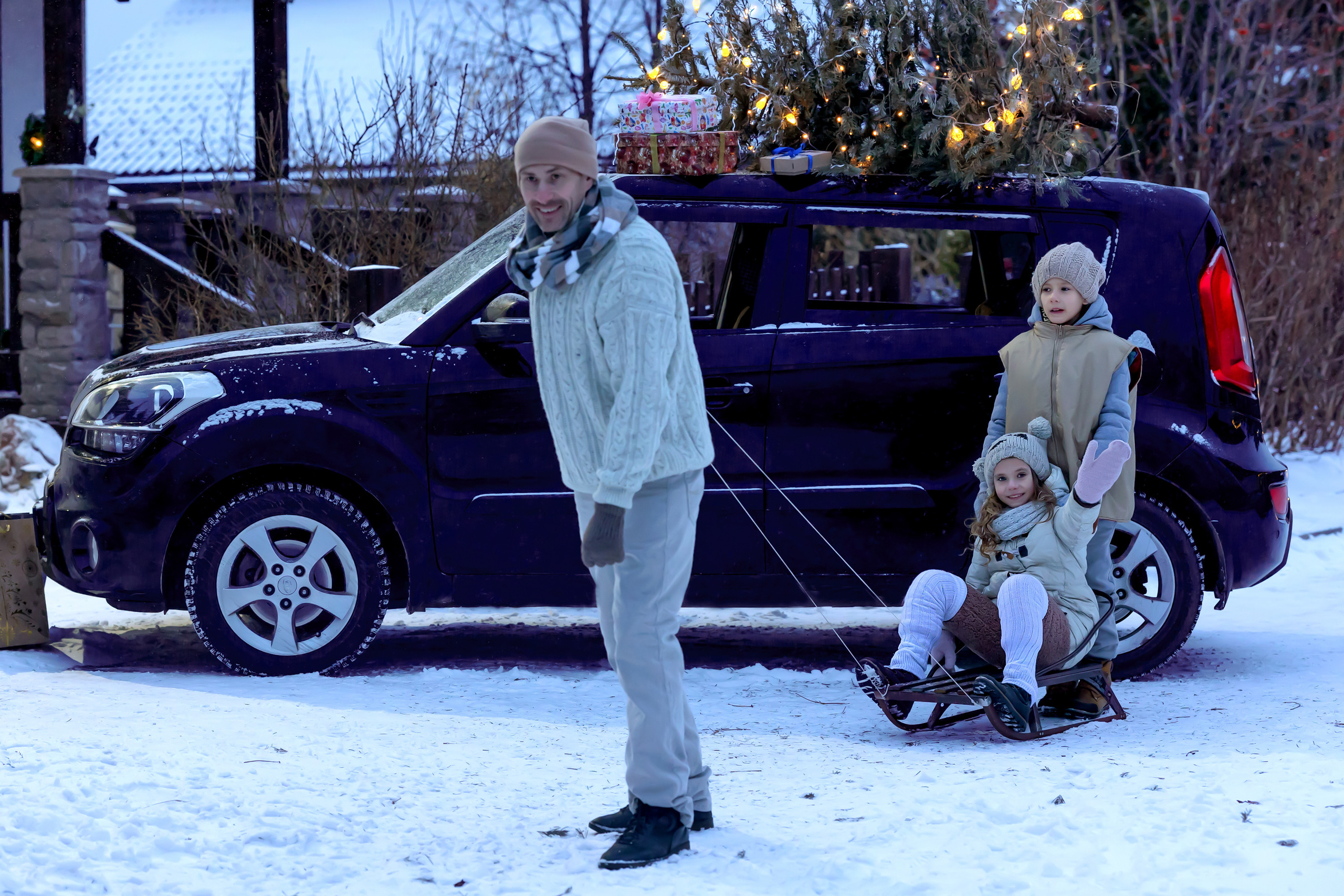 Новогодняя машина с ёлкой на крыше.  Папа мужчина везет девочку на санках