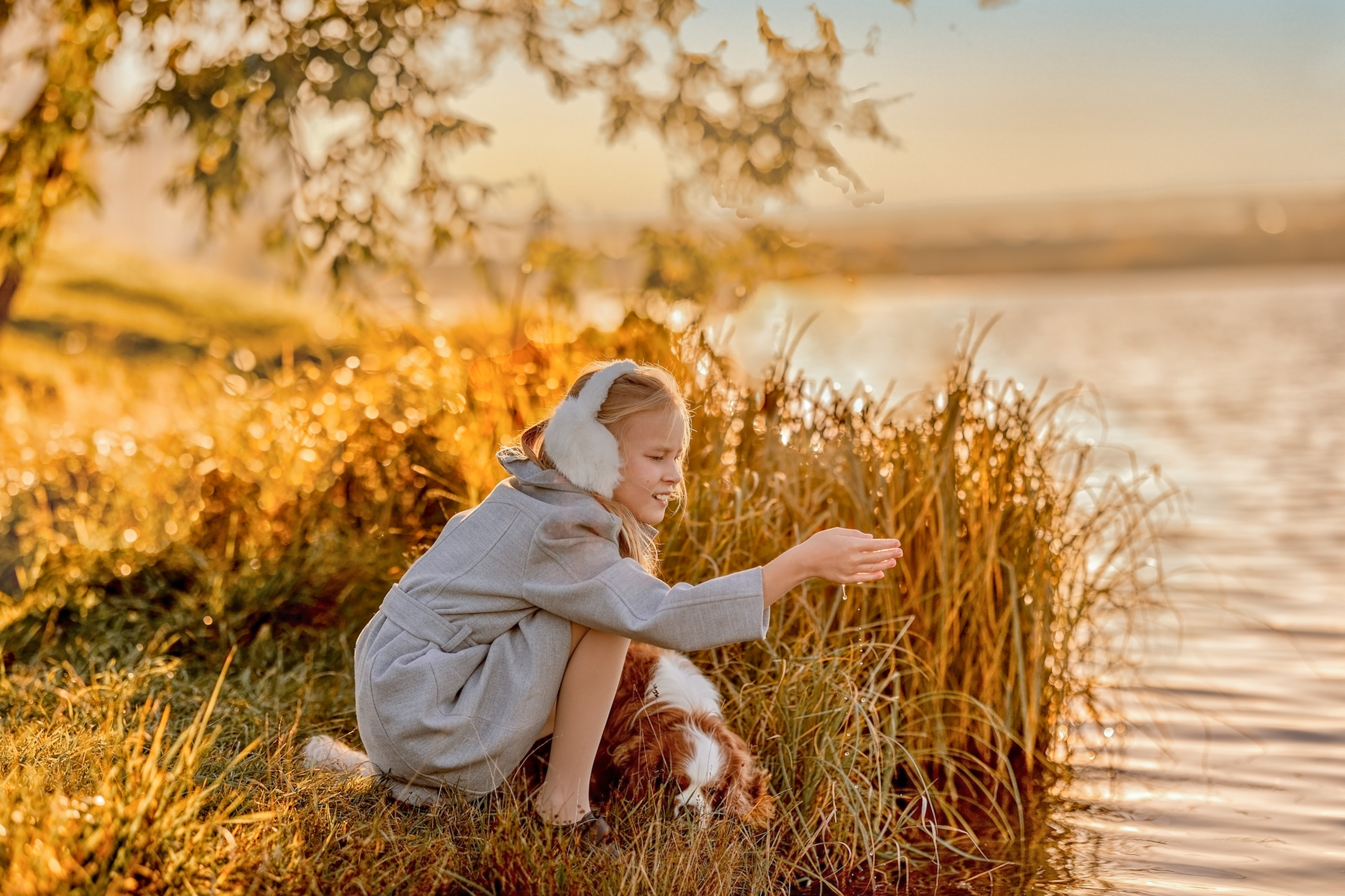 Девочка осенью возле озера с собакой 