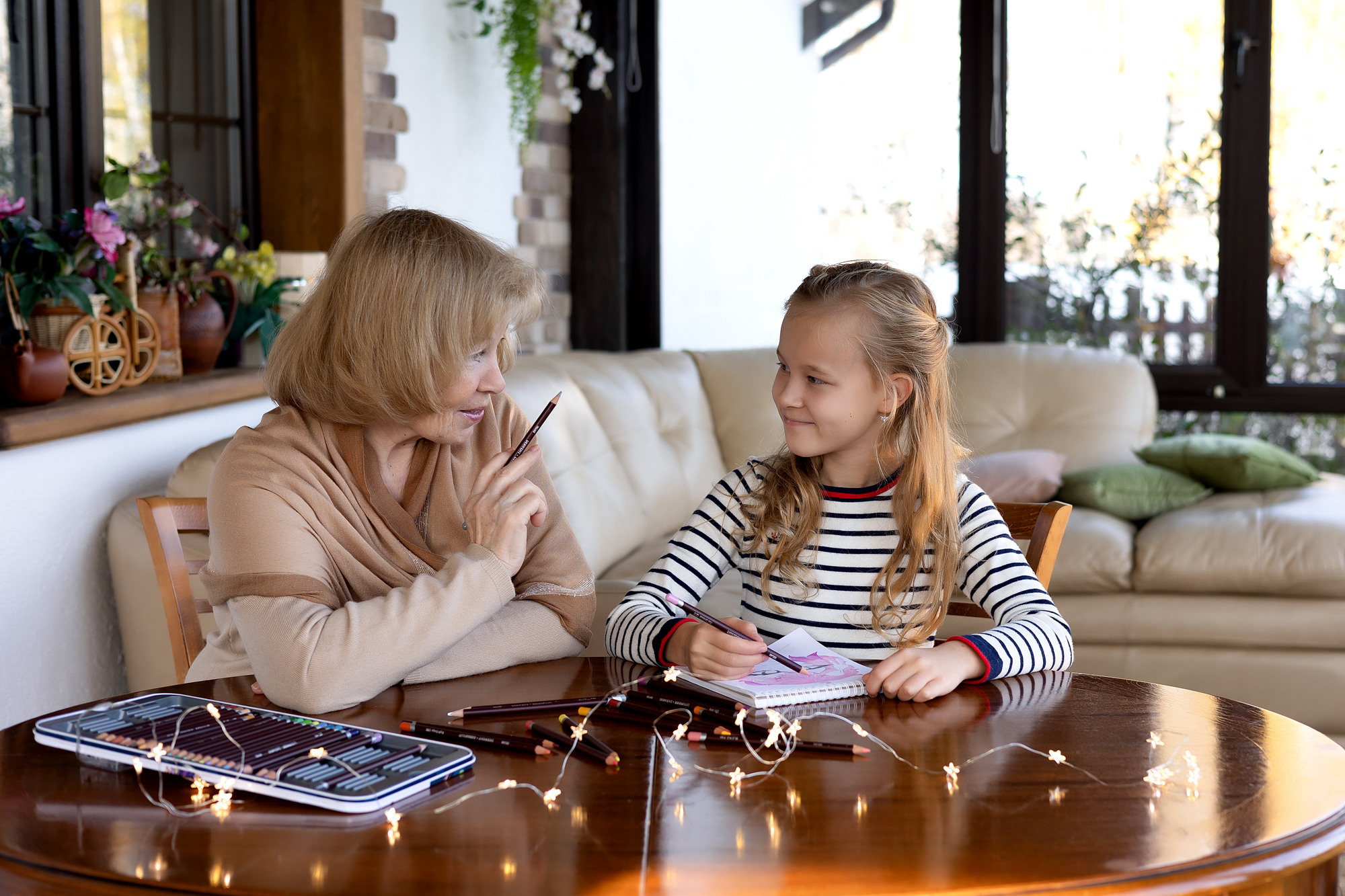 нежная фотосессия бабушки и внучки. Бабушка рисует с внучкой