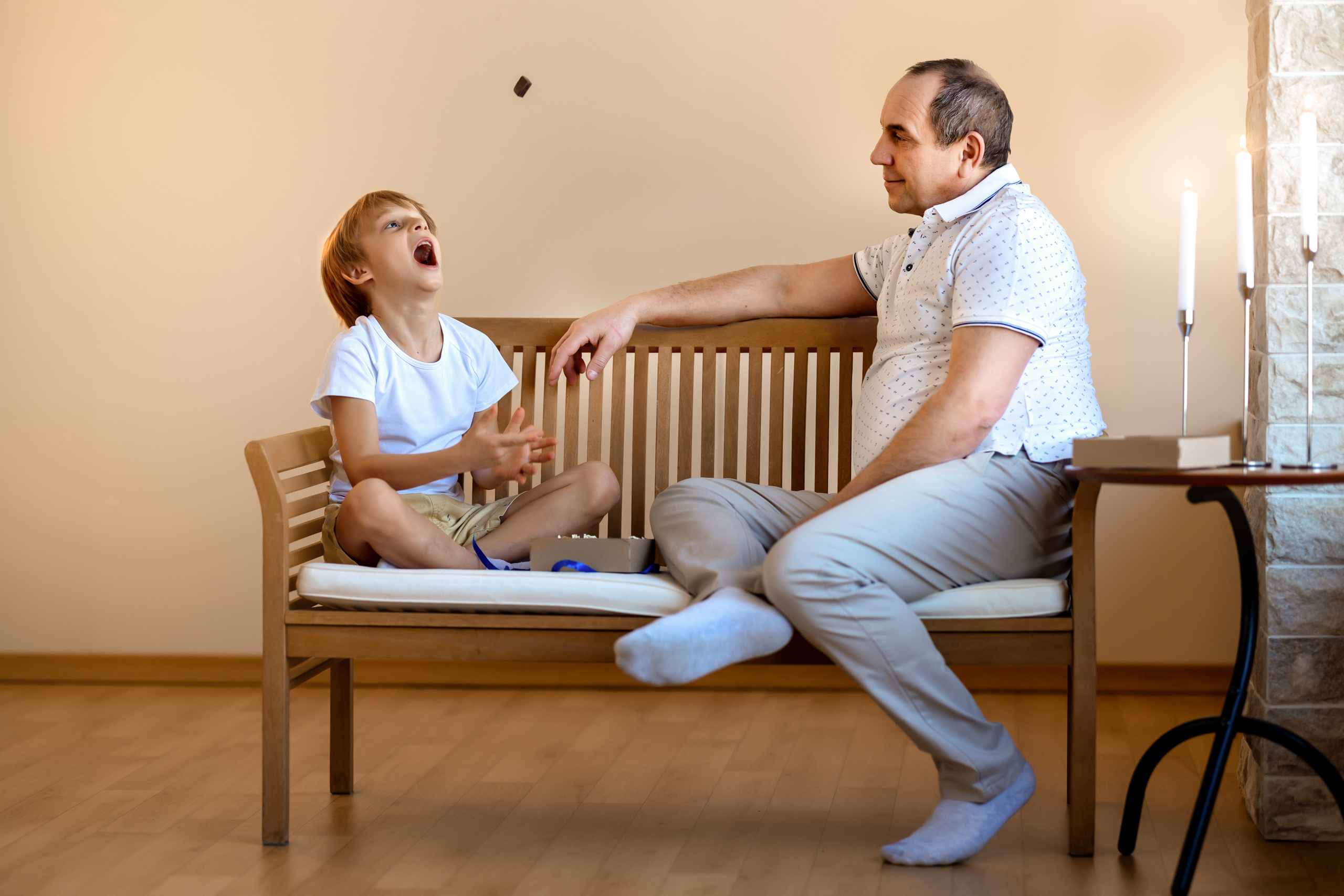 папа играет с сыном на лавочке