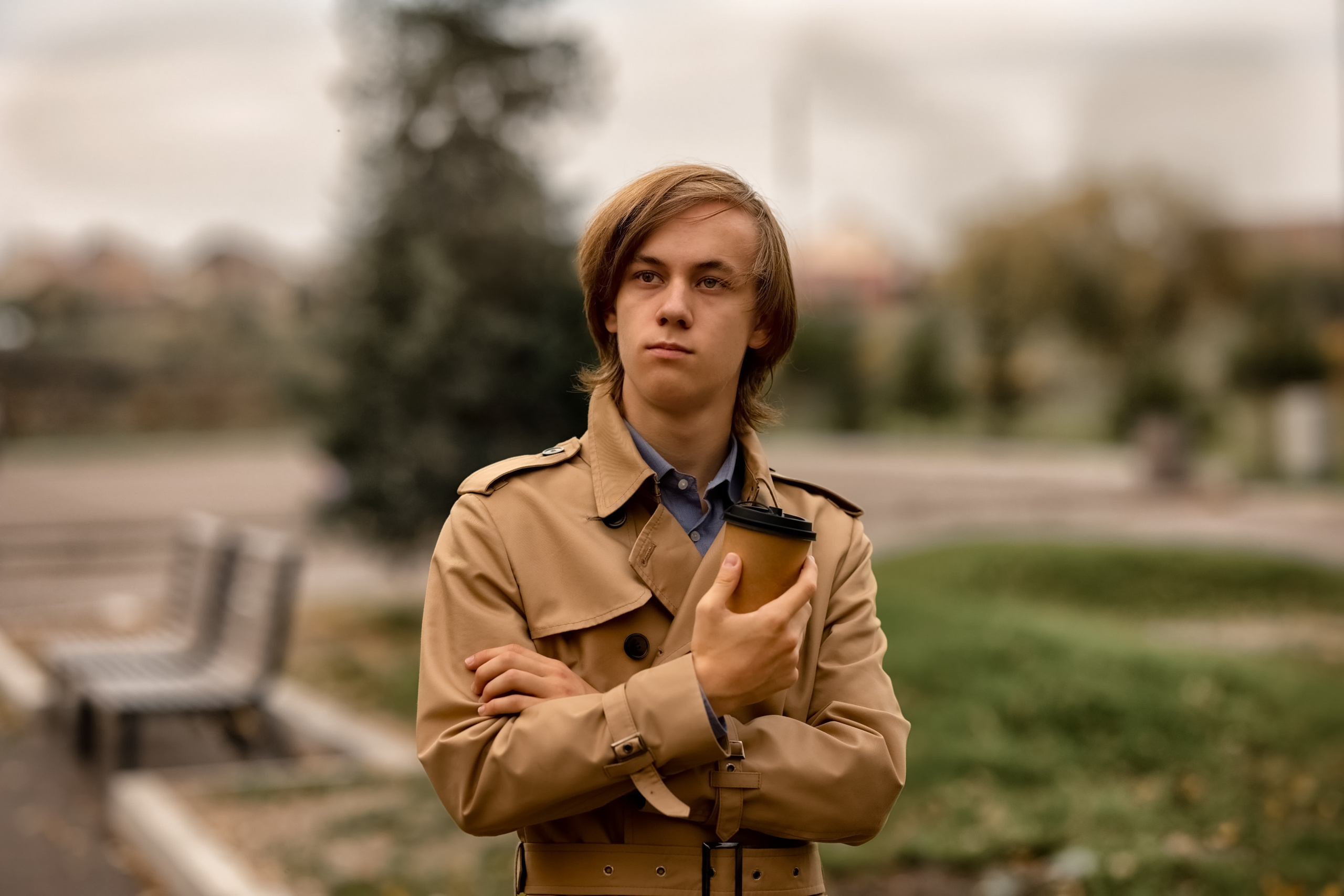 Счастливый мужчина осенью в парке пьет кофе