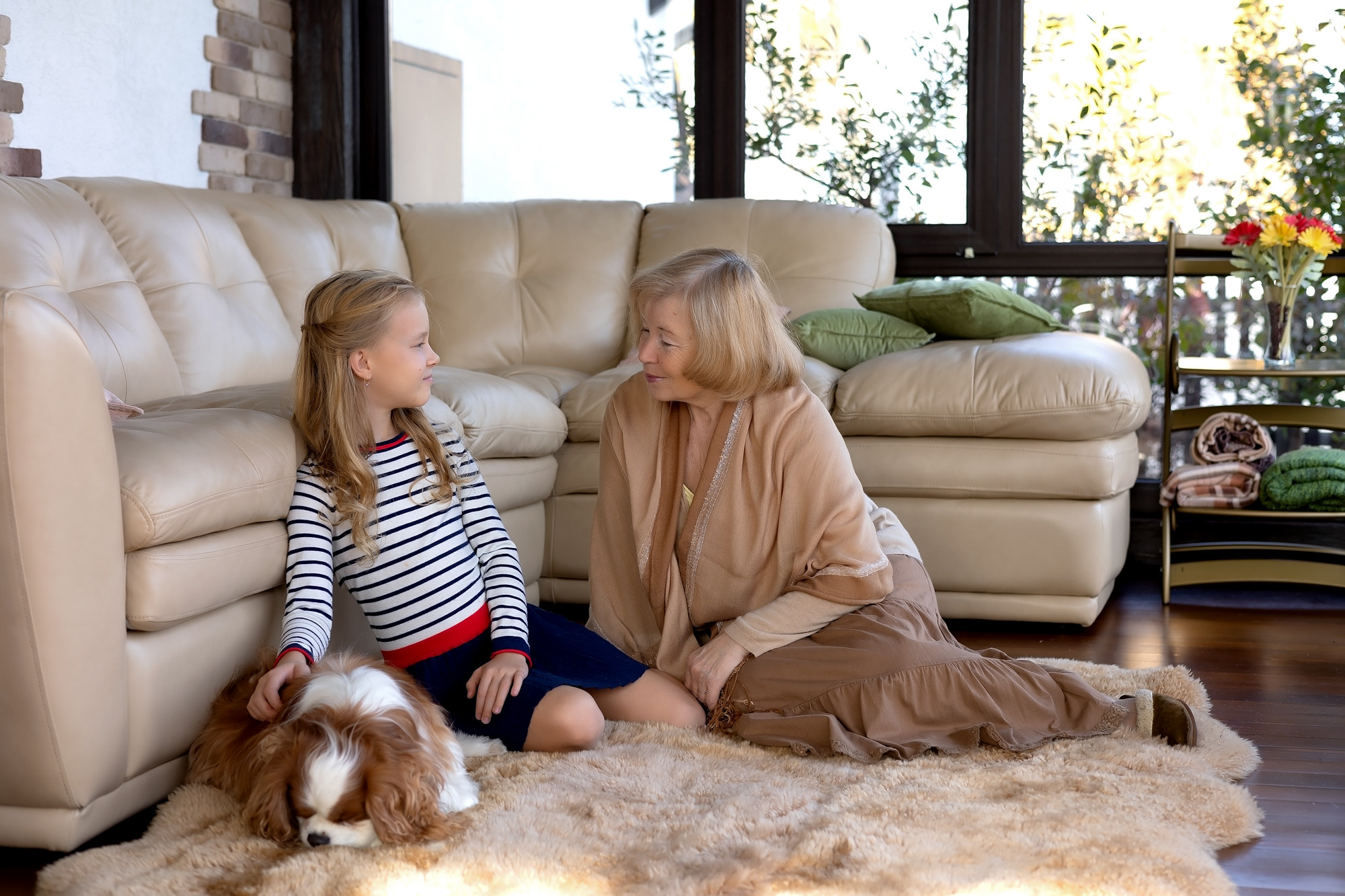 нежная фотосессия бабушки и внучки. Бабушка играет с девочкой