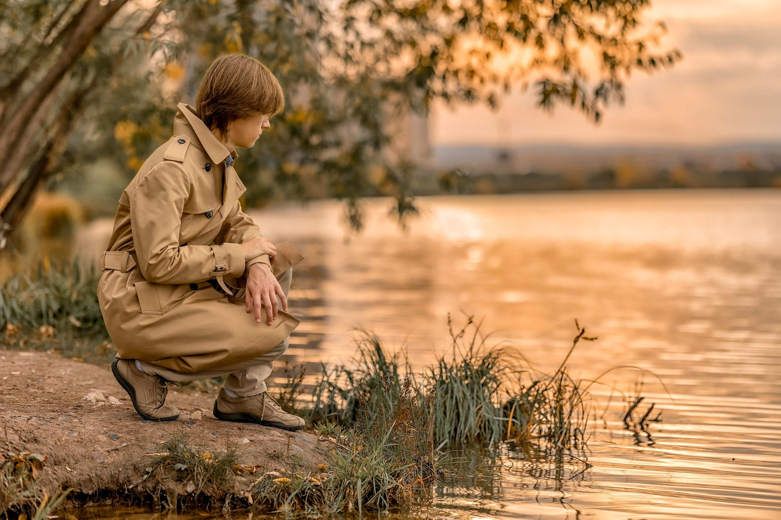 Мужчина возле озера осенью