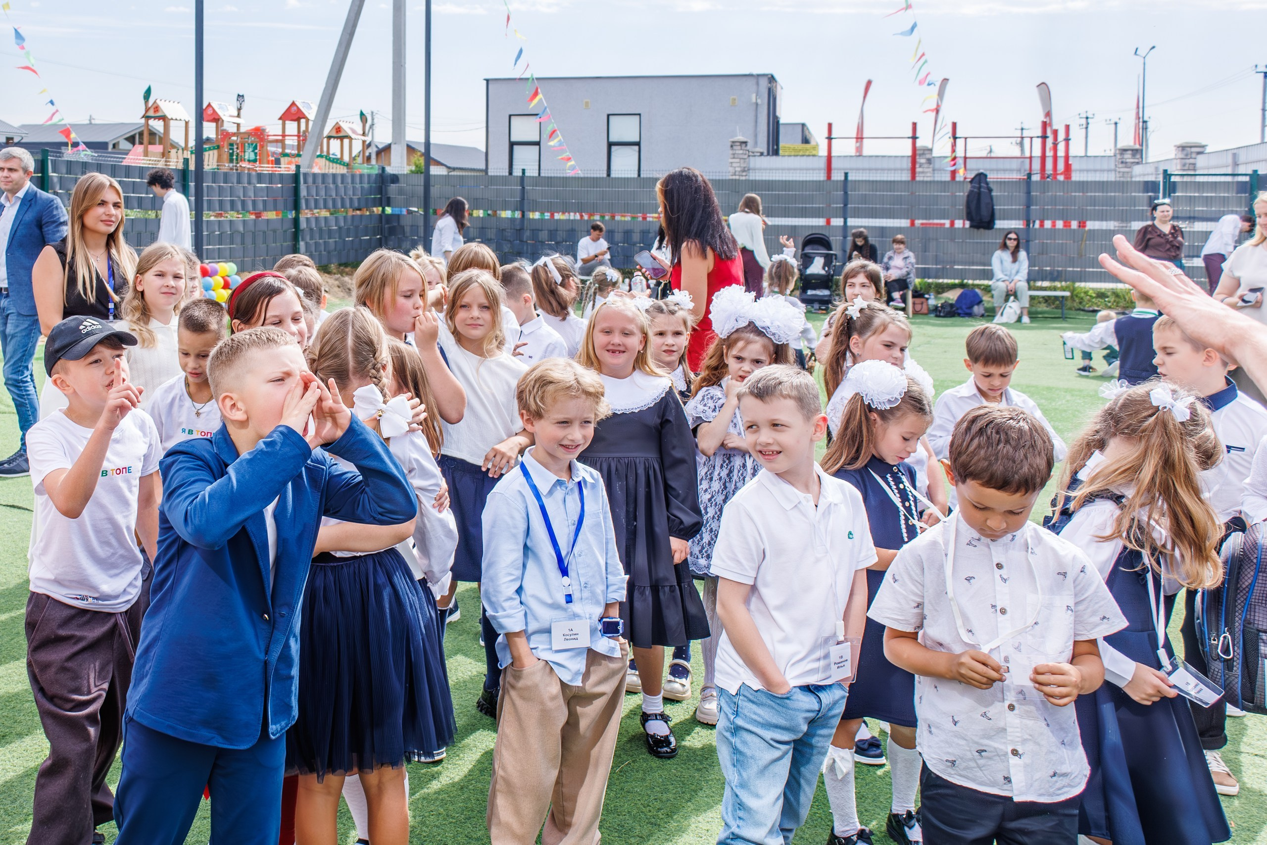 дети обнимаются, радуются встрече с друзьями после каникул; аниматоры на школьном празднике 1 сентября, дети смеются и радуются