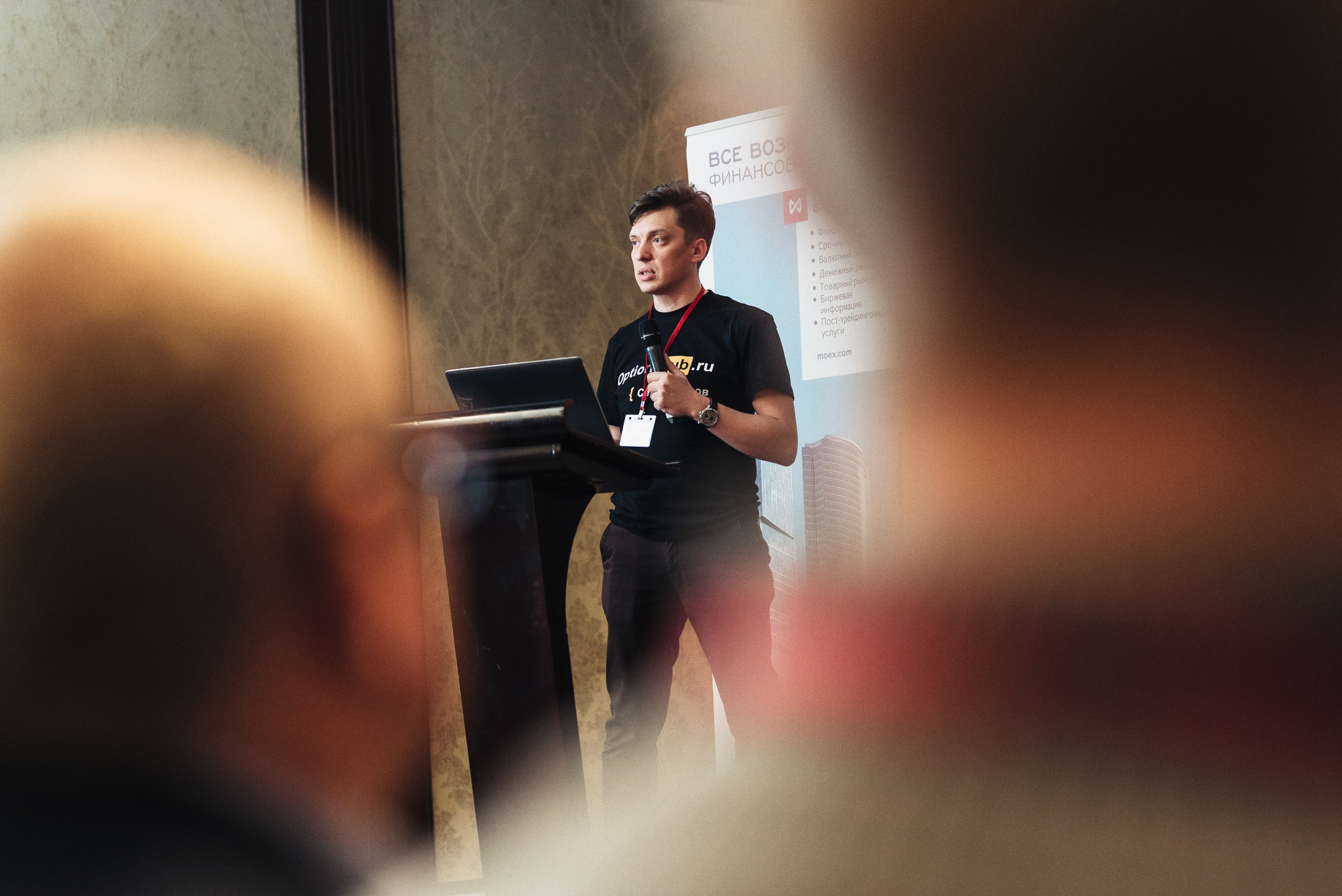 Фотография делового мероприятия – крупный план участника с микрофоном.