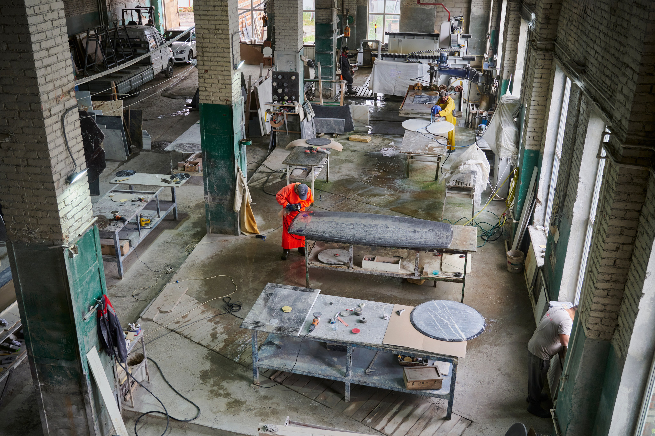 Производственный участок сверху, рабочий у оборудования в цехе