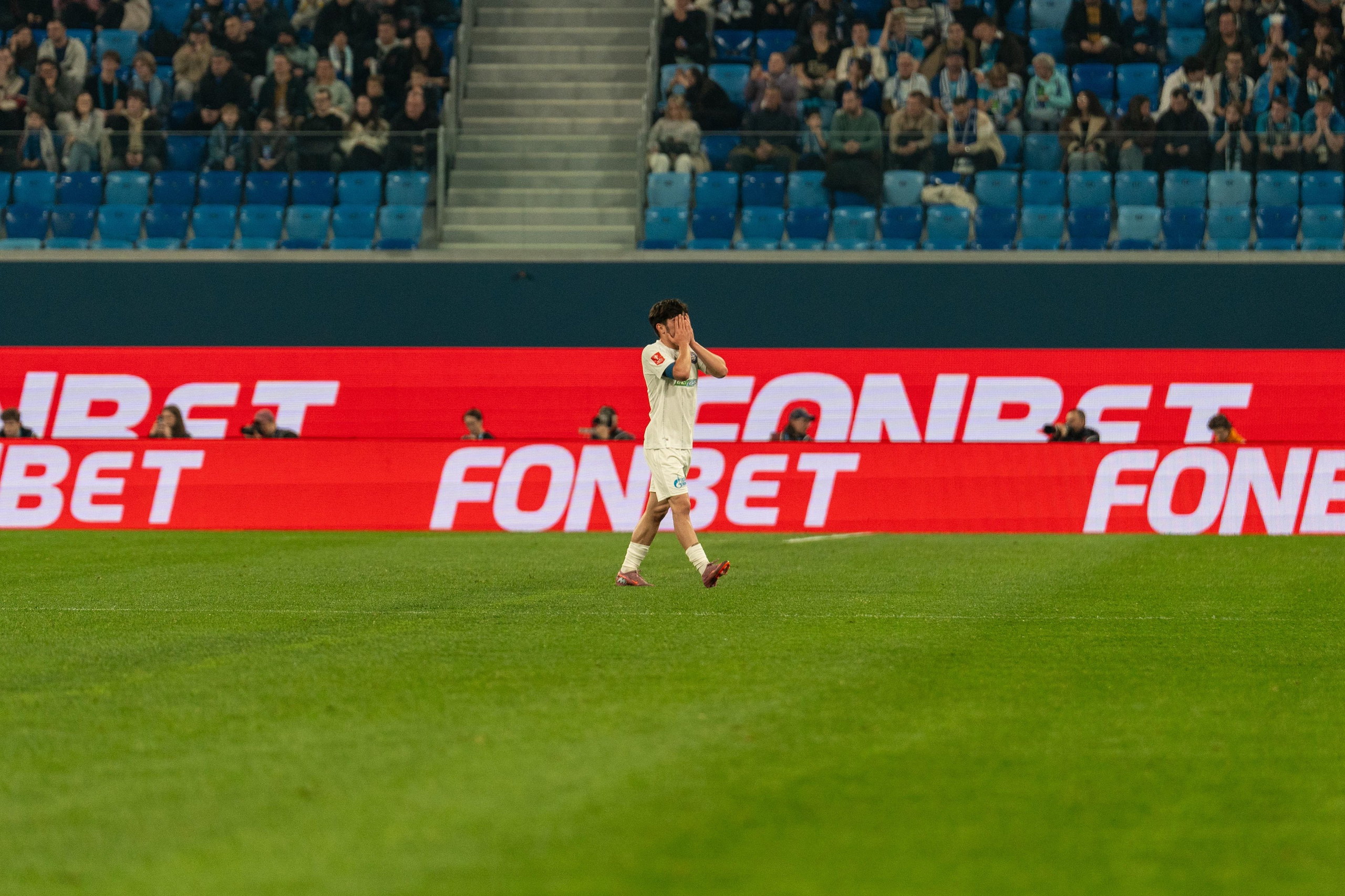 Разочарованный футболист Оренбурга держит голову рукой репортажный фотограф спорт съемка