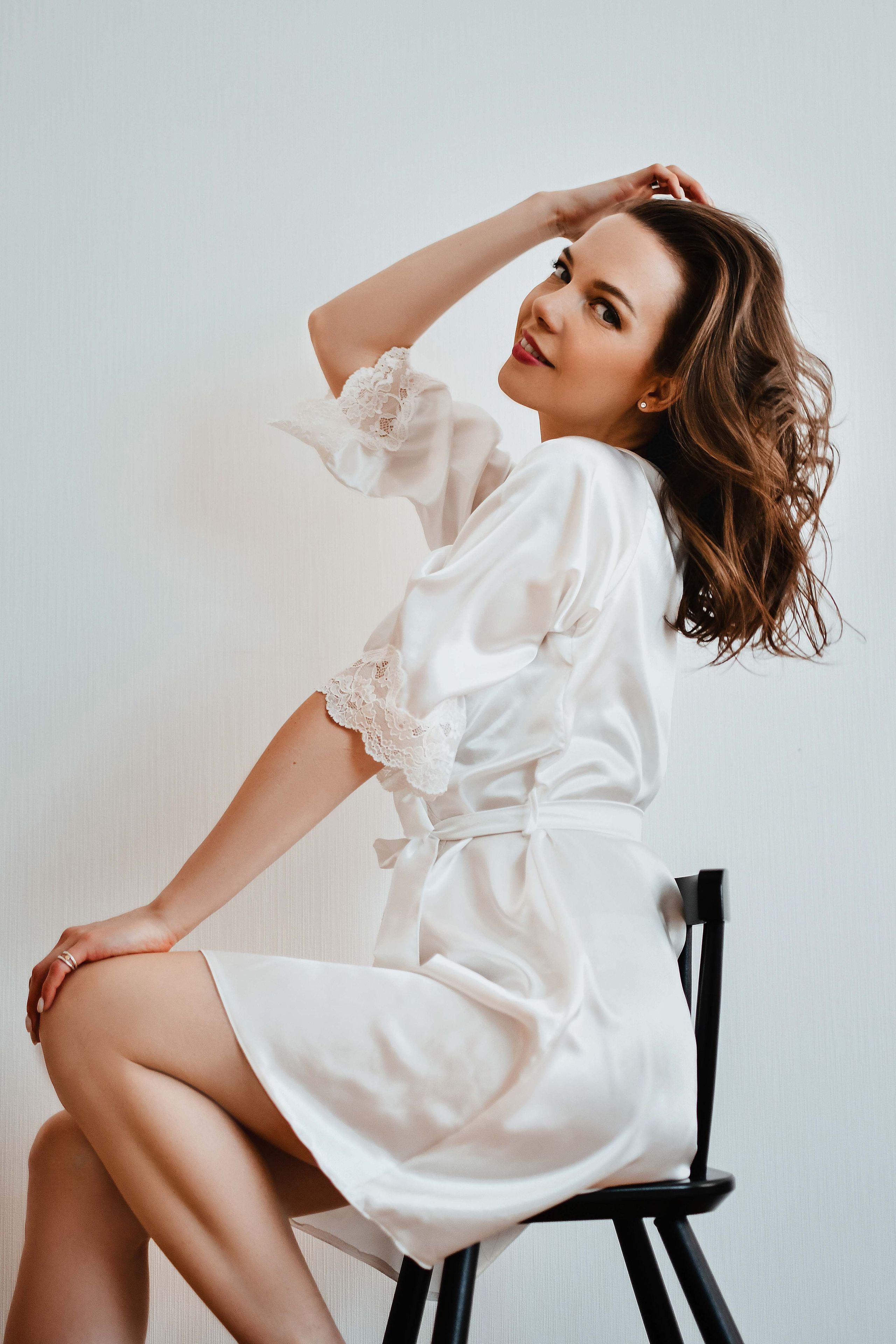 Девушка в белом шёлковом халатике сидит на стуле