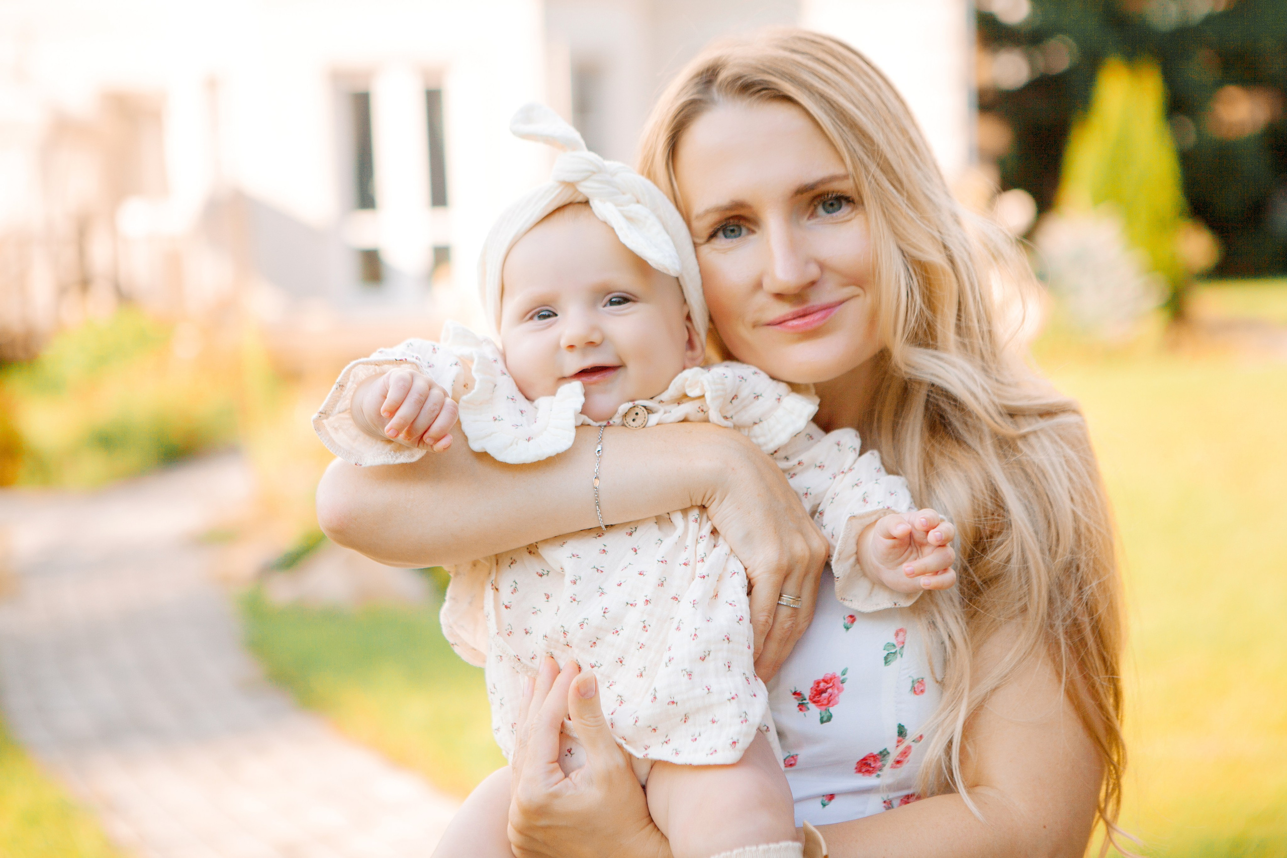 мама с дочкой в красивых платьях позируют фотографу летом