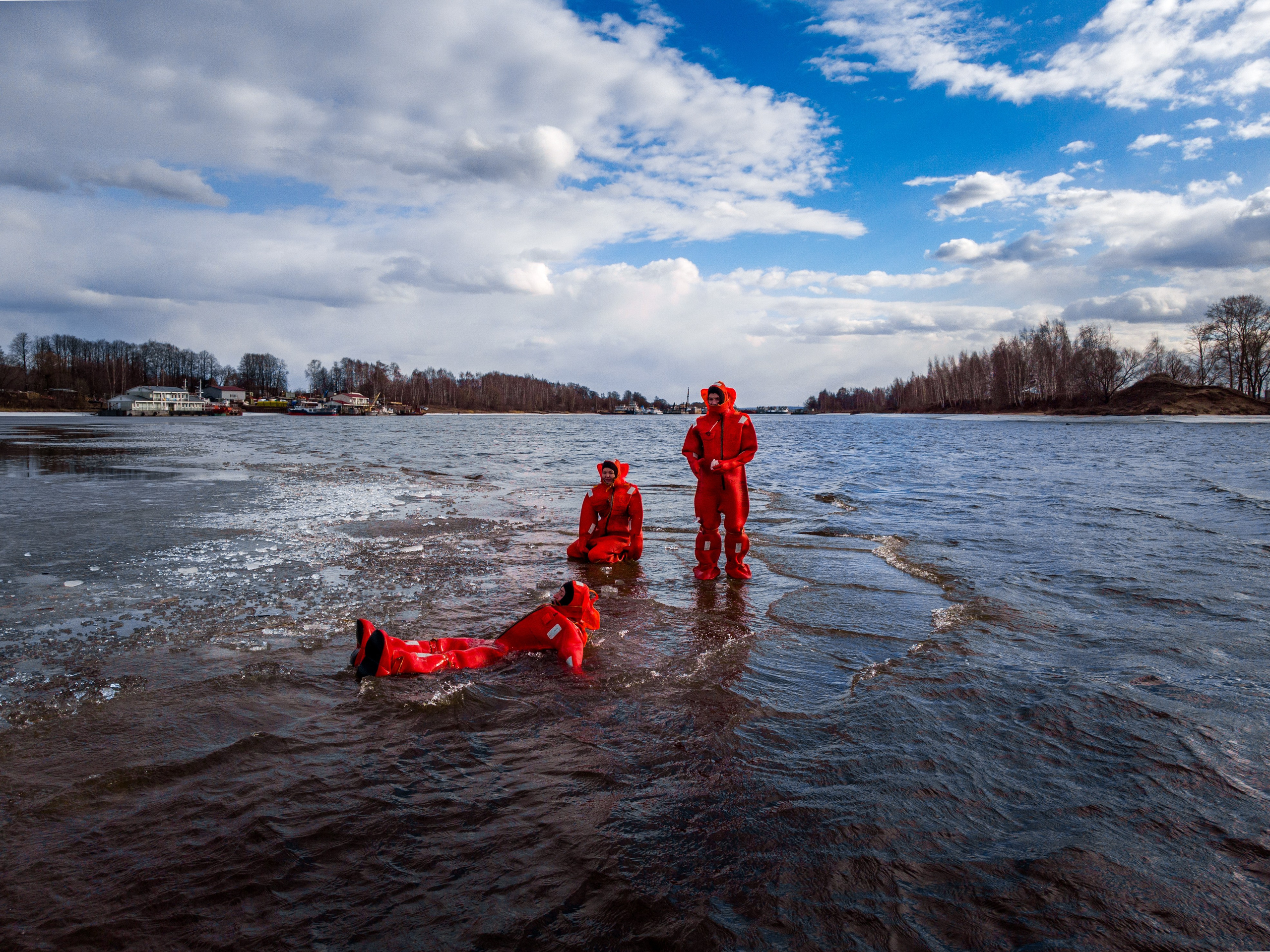 Люди купаются среди льдин, в спасательных оранжевых термо костюмах, айс флоатинг Ярославль