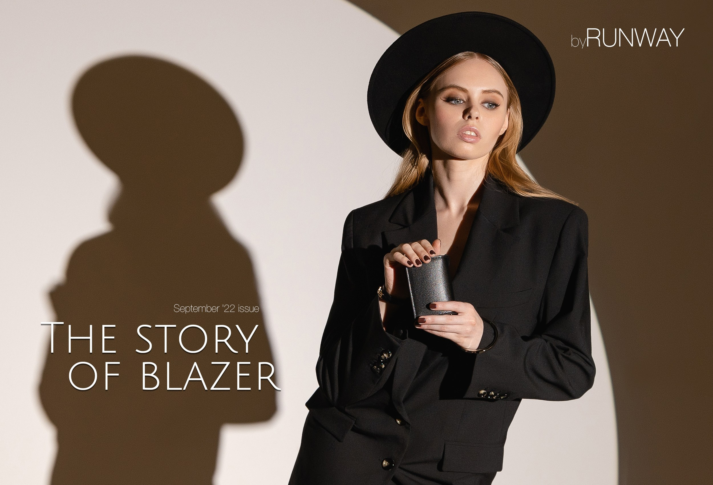 Девушка в чёрное платье и чёрном блейзере держит в руках малюсенькую сумочку