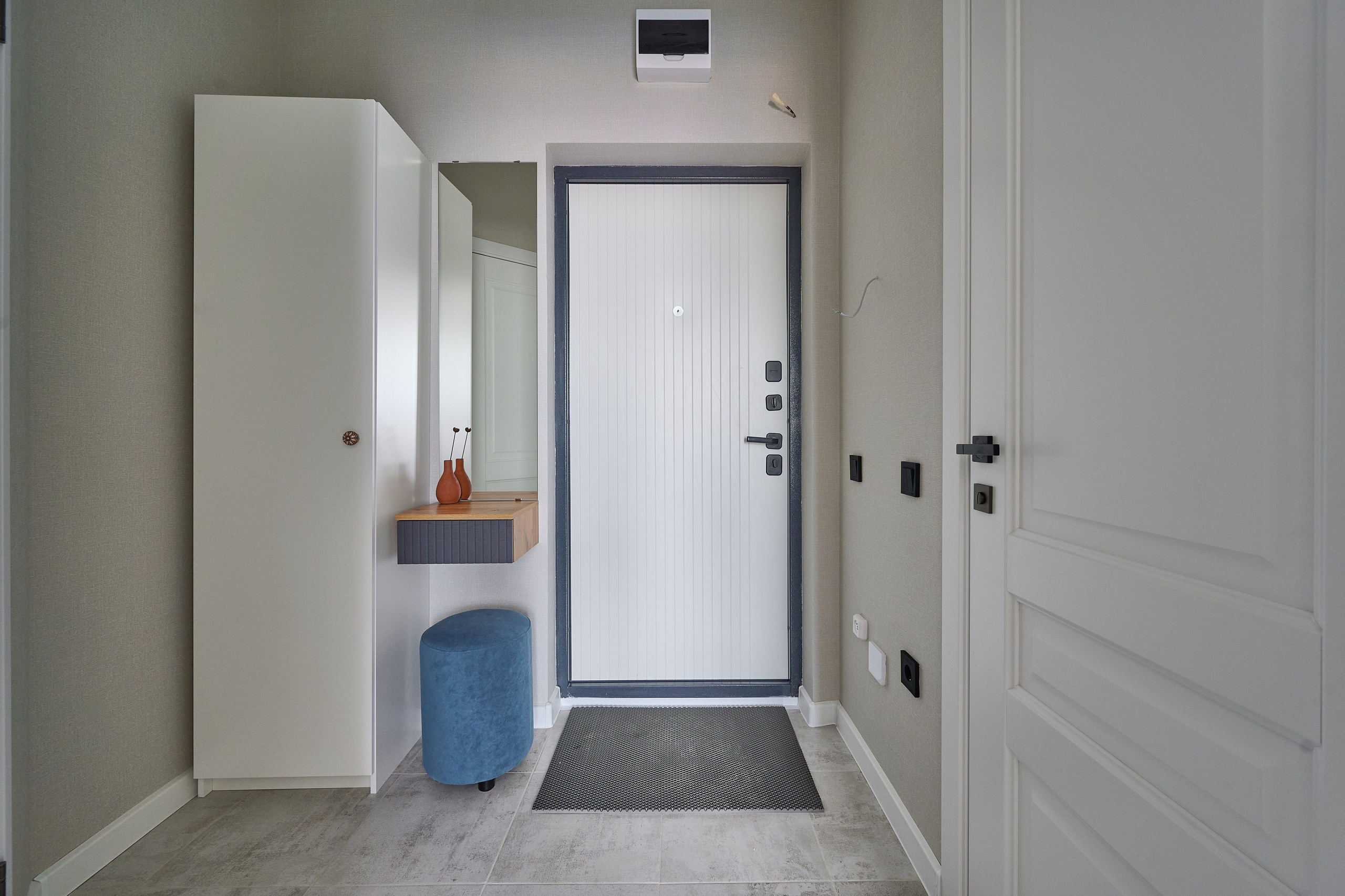 белый коридор белая входная дверь  белый большой шкаф синий пуфик 