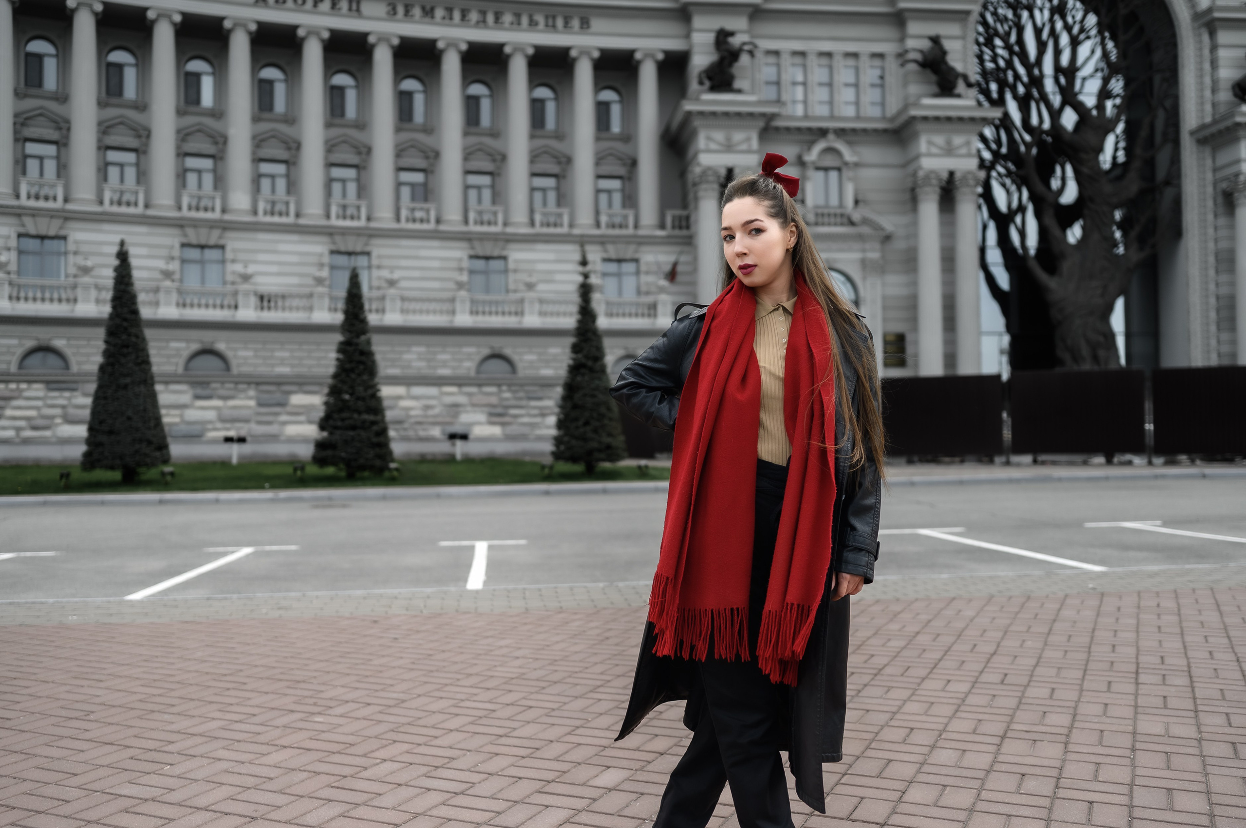 Модель в красном шарфе на фоне дворца земледельцев