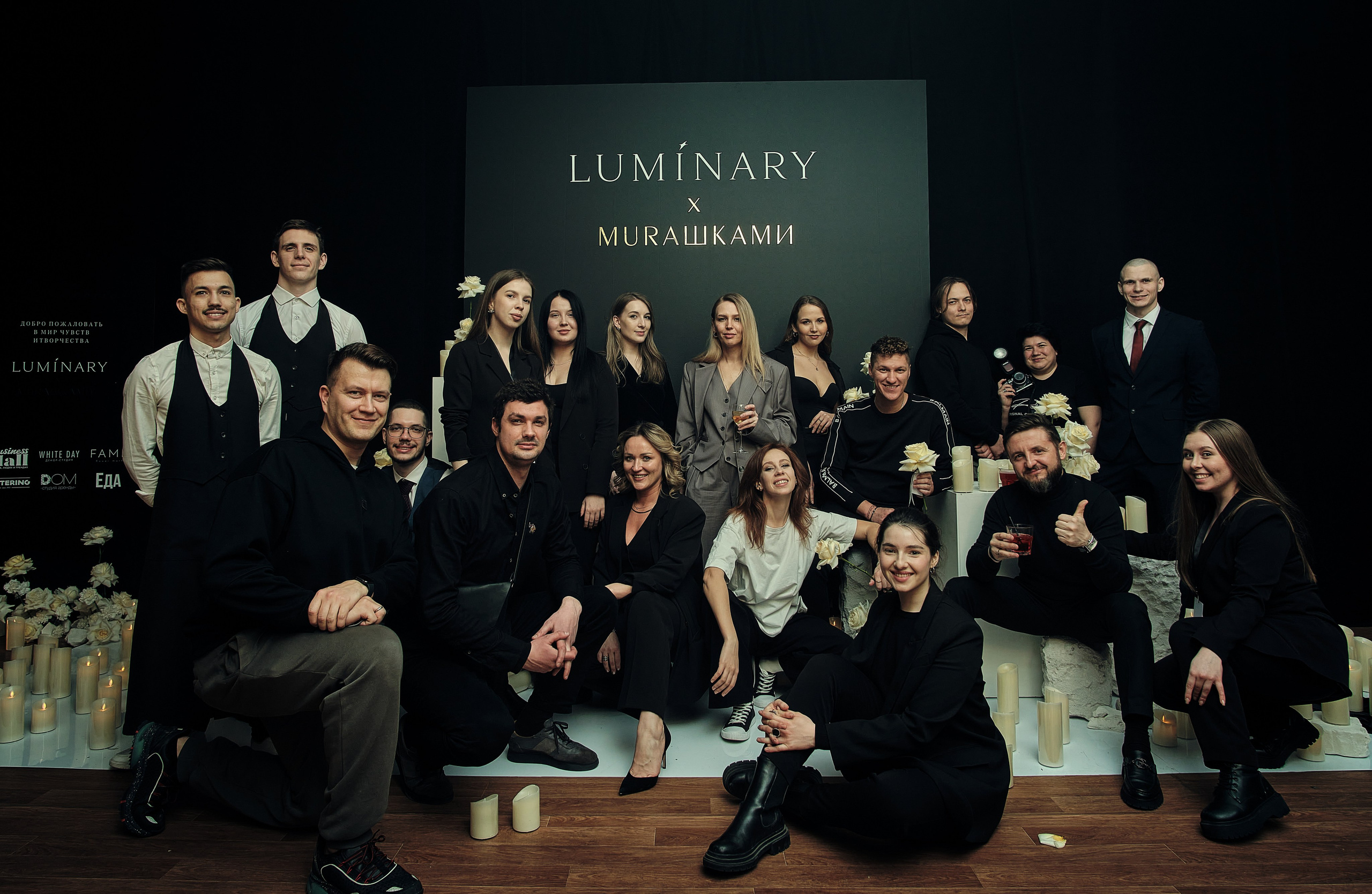 Командная работа: сотрудники строят башню из деревянных блоков на тимбилдинге на природе под руководством фасилитатора