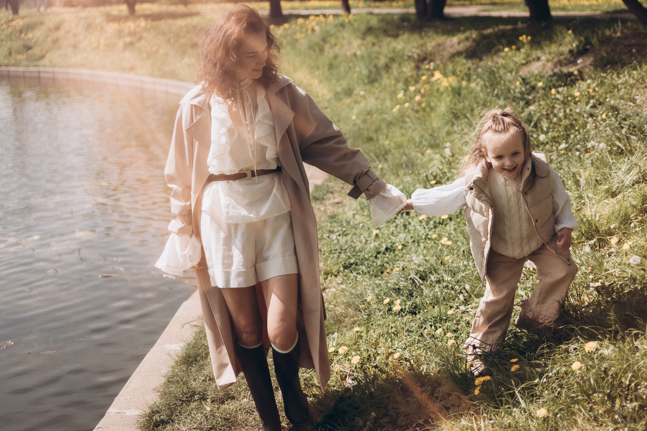 мама с дочкой гуляют в лучах солнечного света
