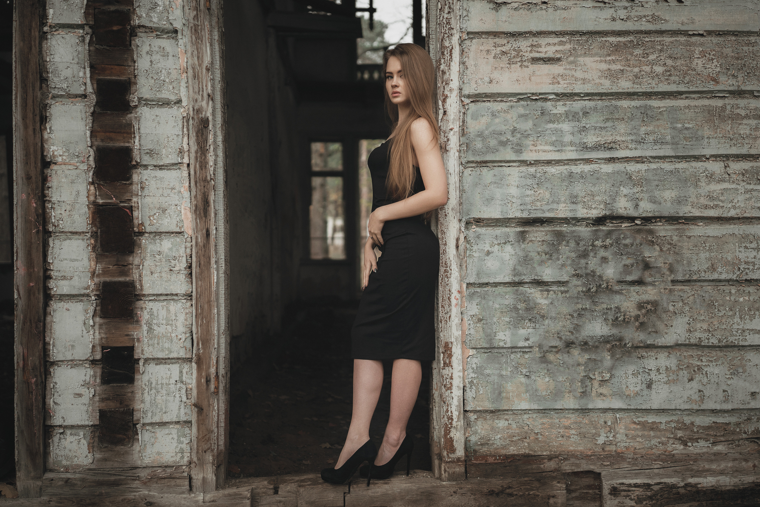 Девушка в черном платье стоит у разрушенного здания. Фотография Романа Яковенко