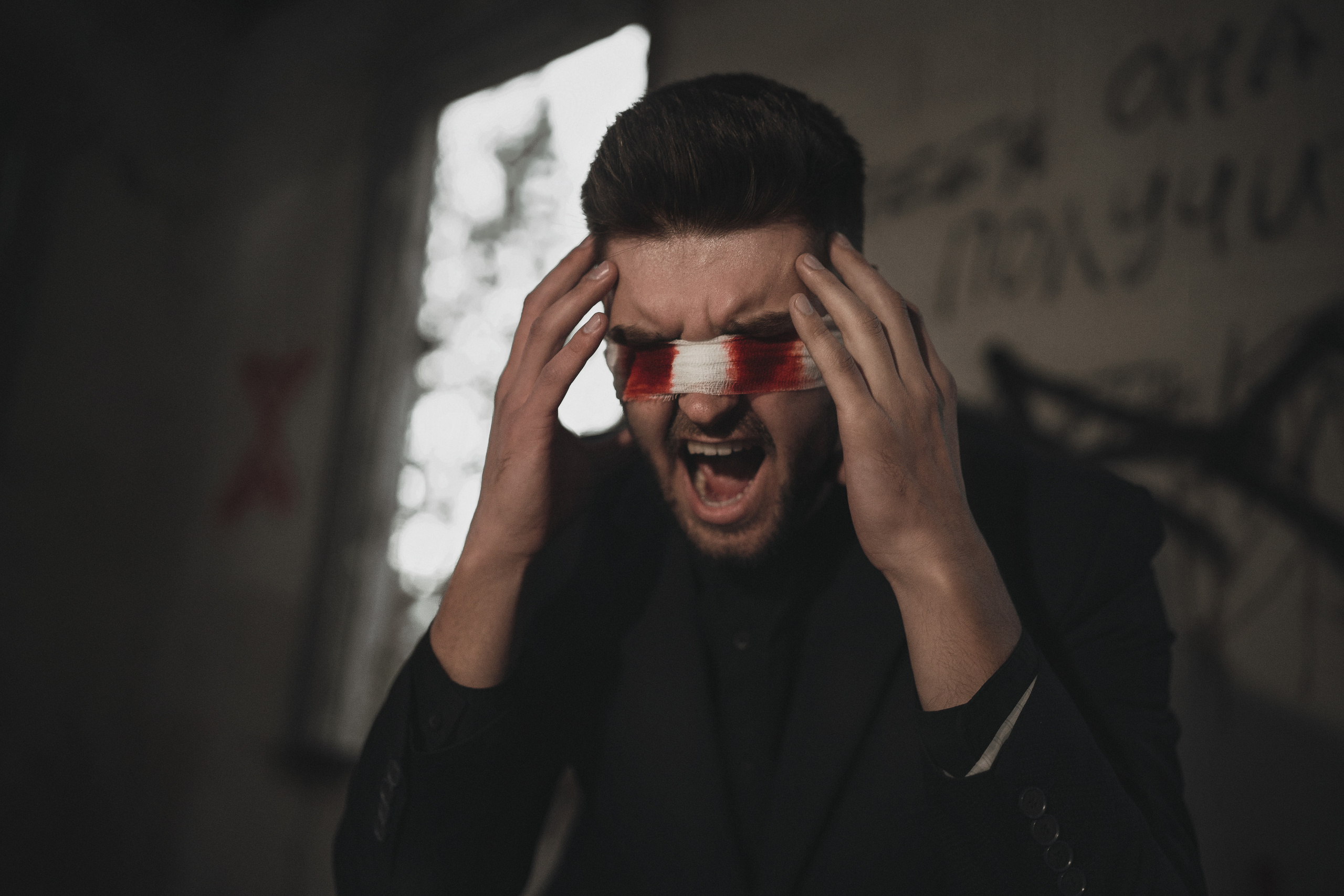 Парень кричит с кровавой повязкой на глазах. Автор: Роман Яковенко
