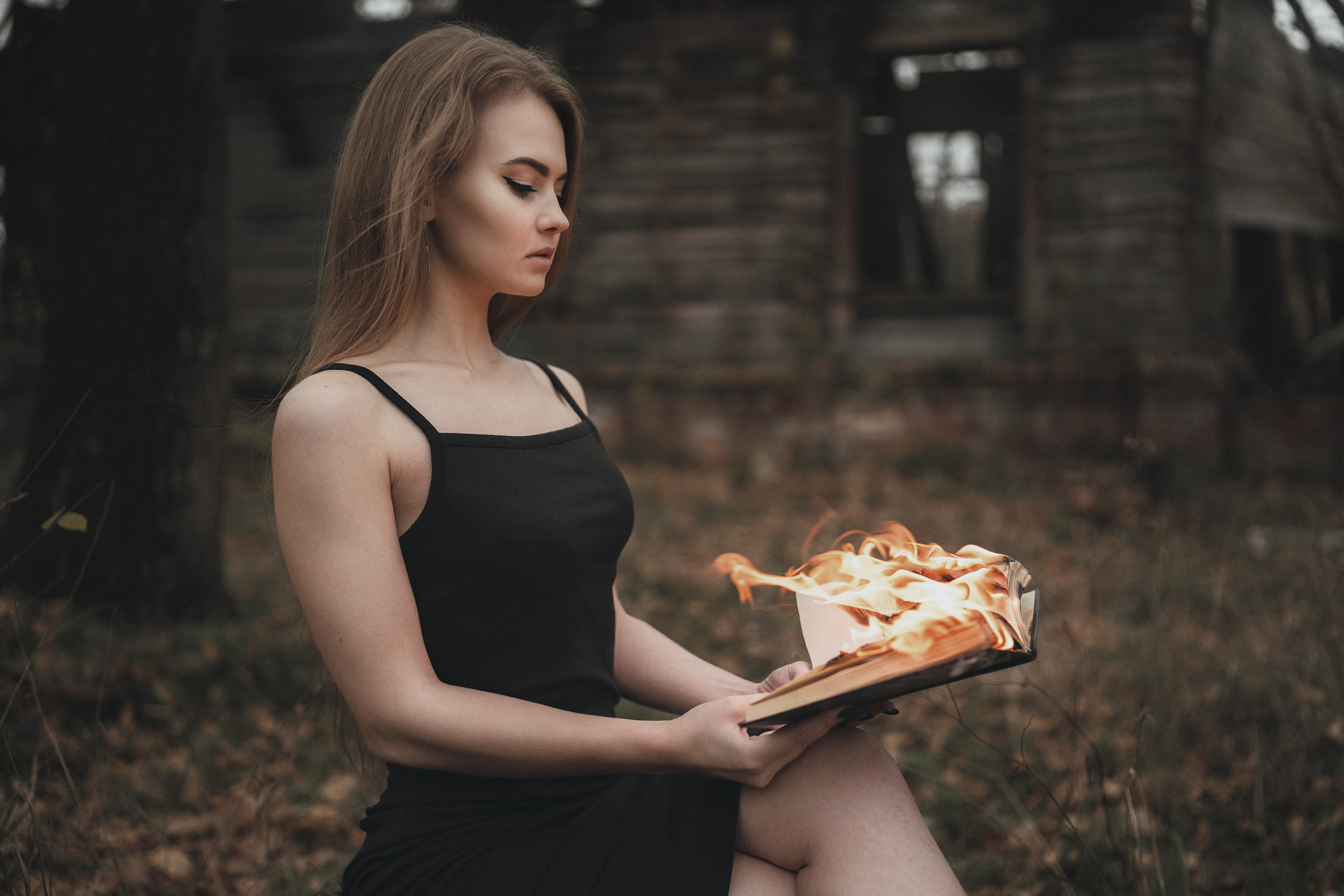 Девушка в черном платье смотрит на горящую книгу. Фотограф в городе Воронеже