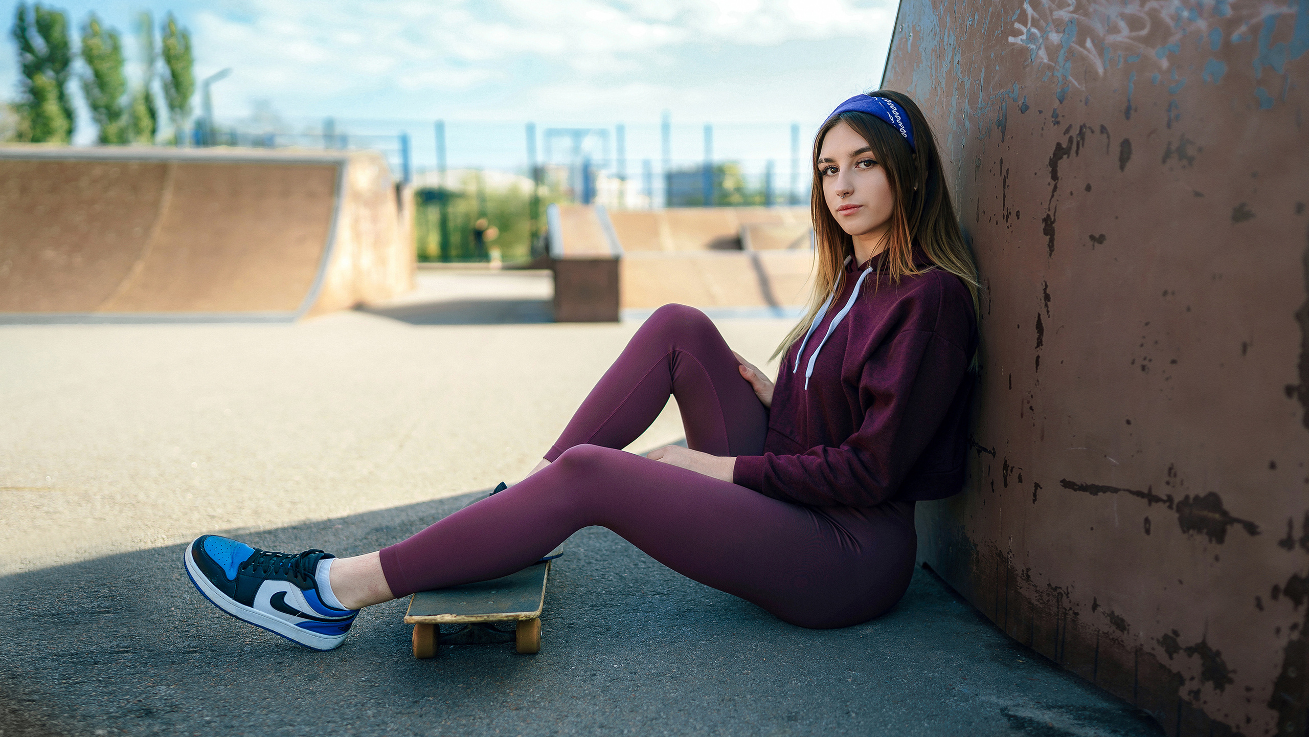 Девочка в спортивном костюме отдыхает в тени и положила ноги на скейт. Фотограф в городе Воронеже