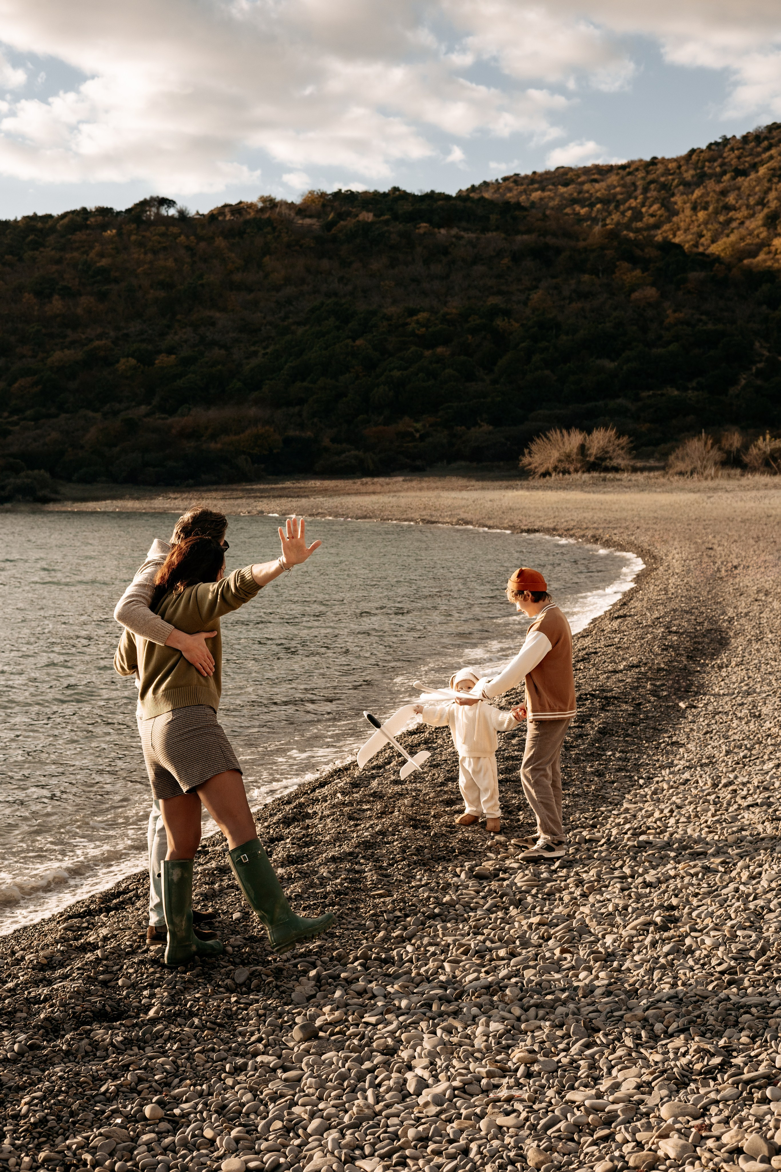 Семья наслаждается последними лучами солнца у моря