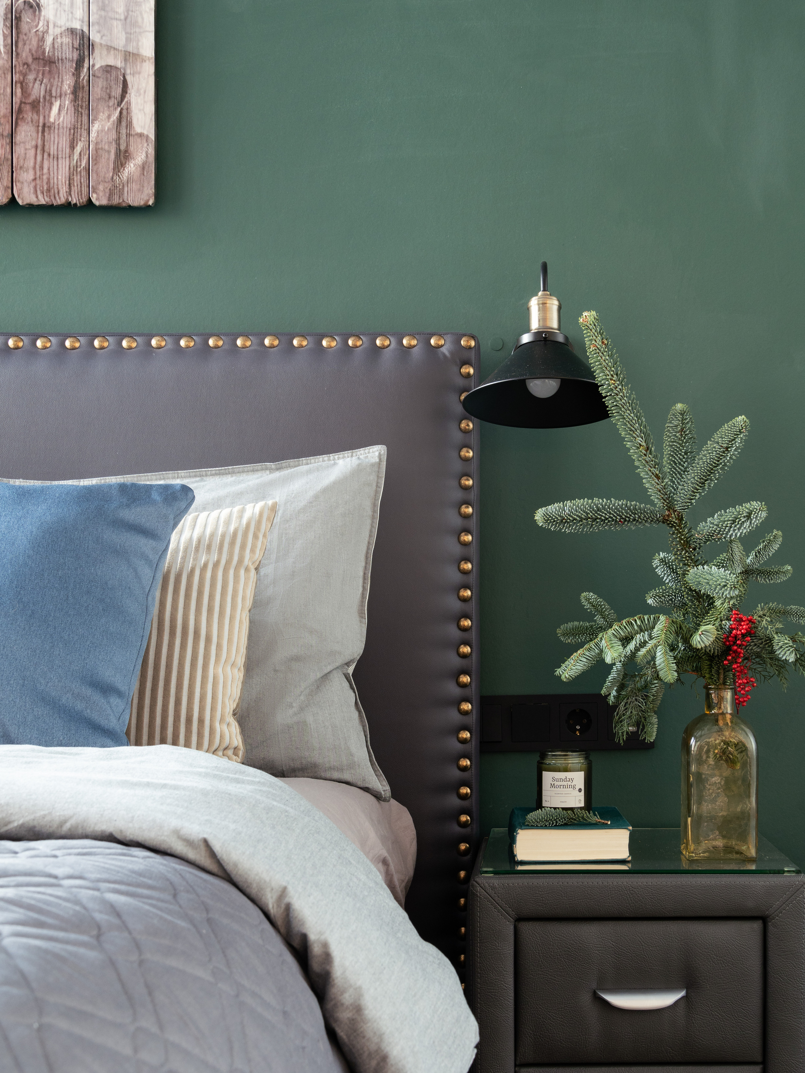 Спальня с тумбочкой елочной веткой и подушками