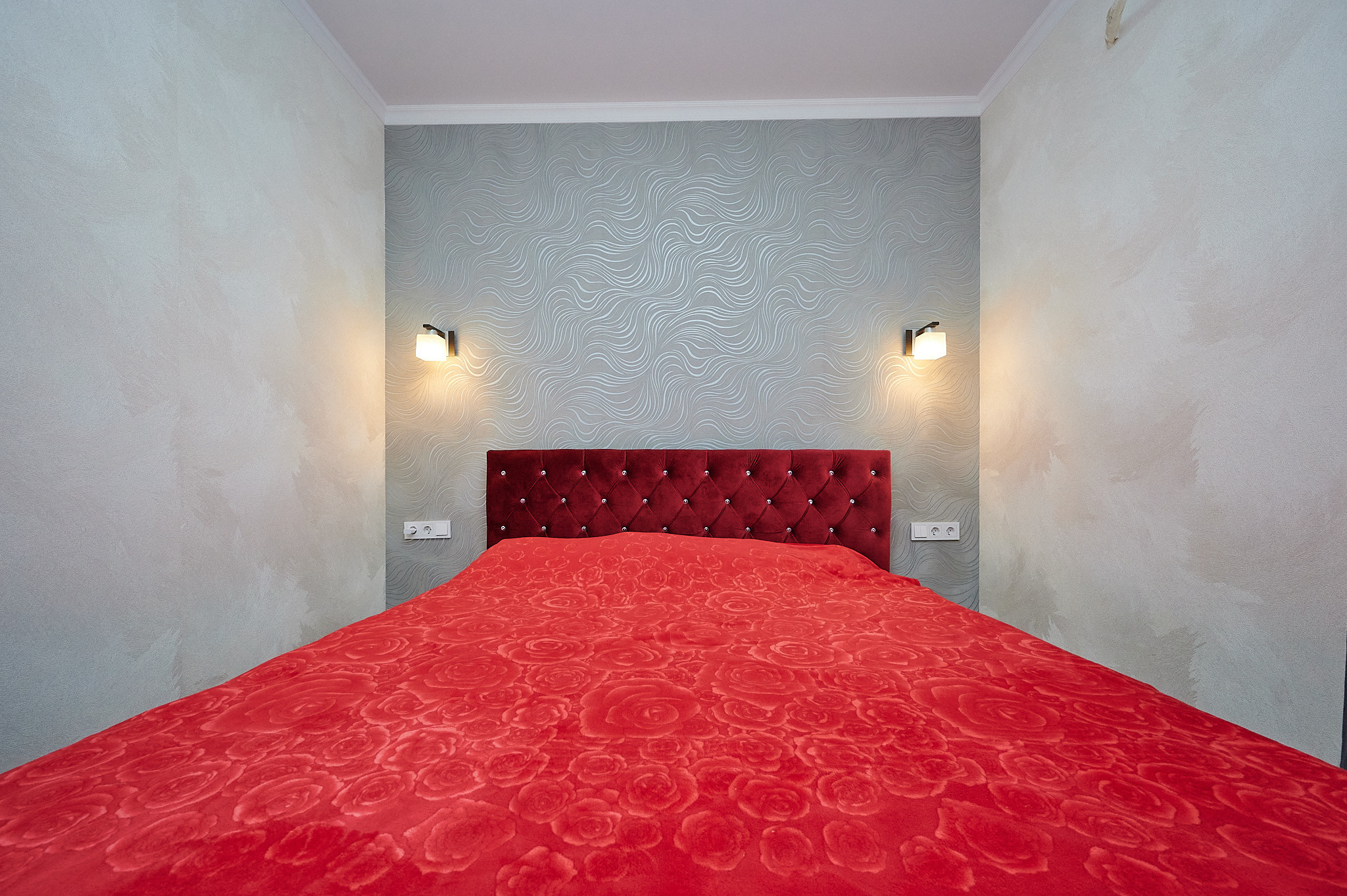 комната светлые обои красная кровать  серые шторы 