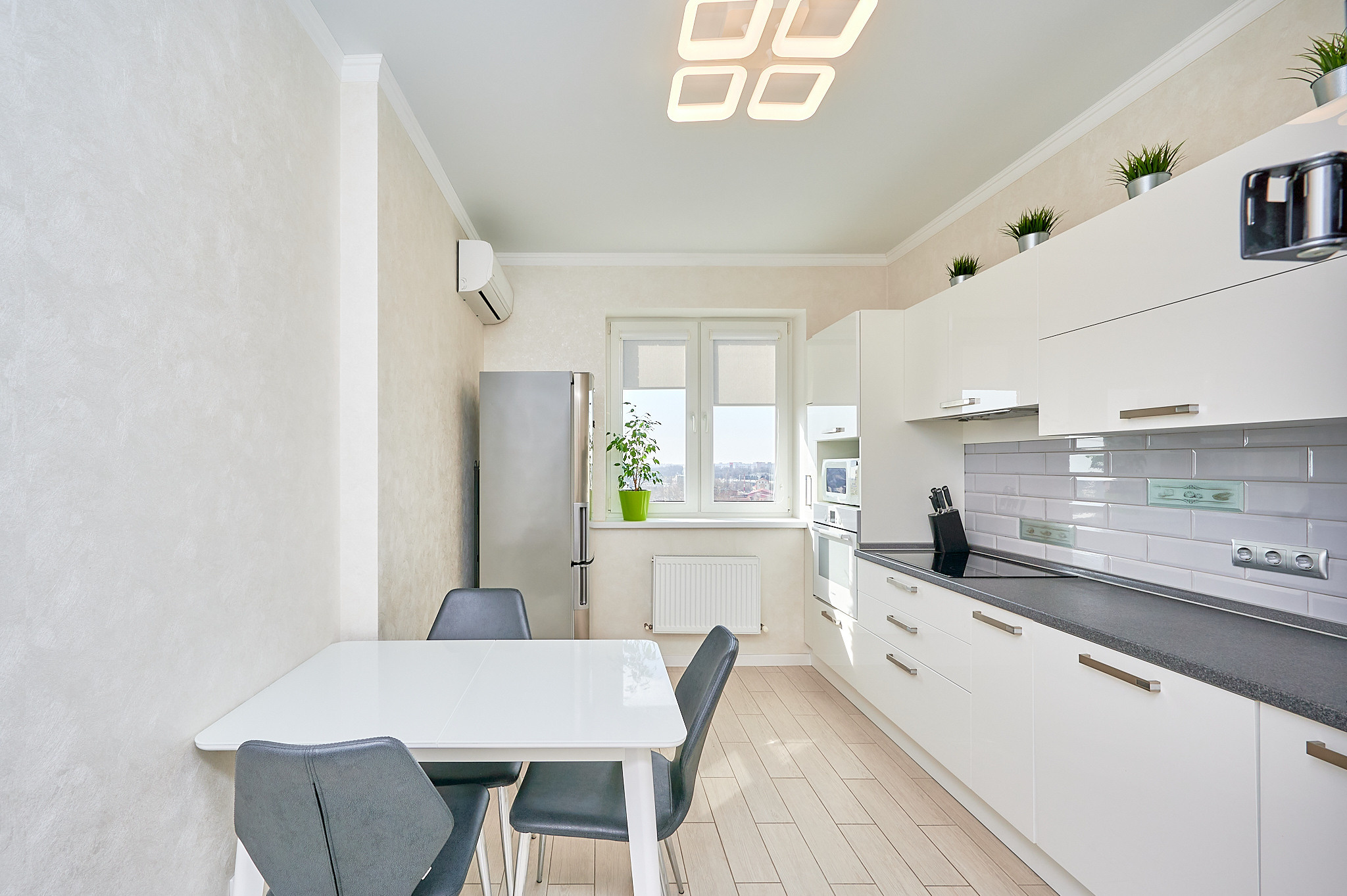 кухня белые оттенки белые шкафчики белый кухонный стол серые стулья 